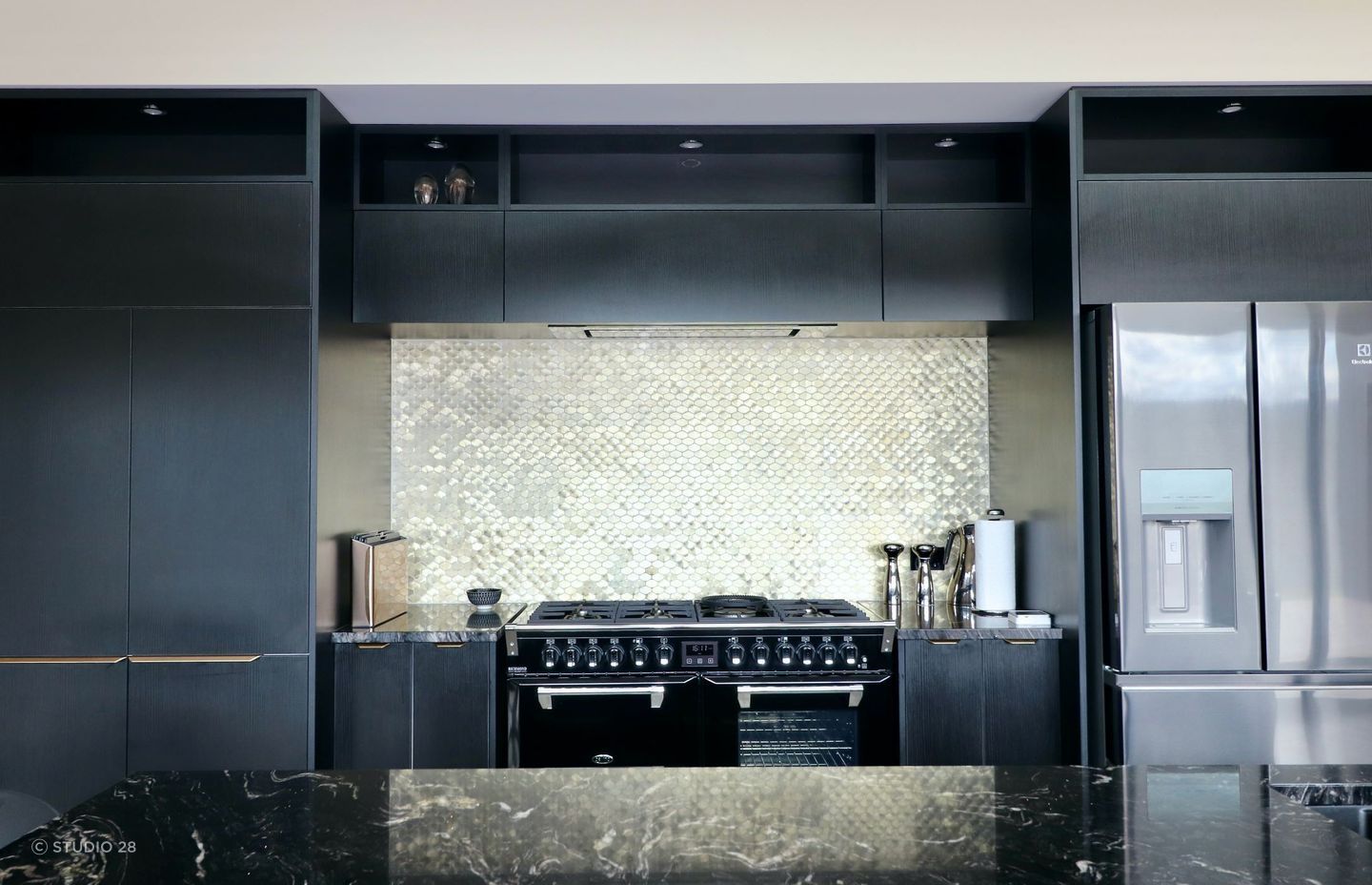 Mosaic tile form with the lustre of aluminium — the best of both worlds with this kitchen splashback of this luxury home.