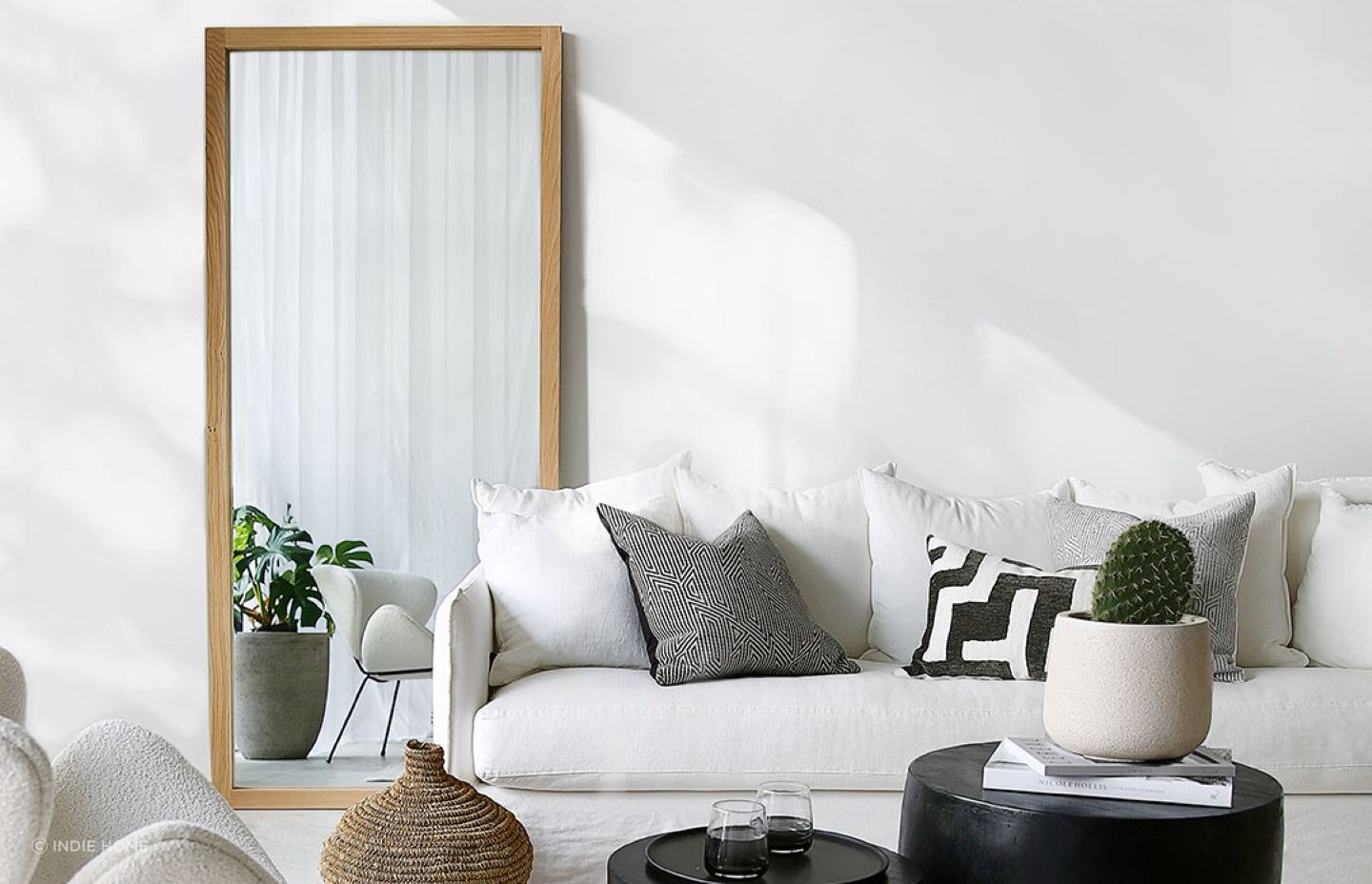 A strategically placed mirror, like this Oak Mirror from Indie Home, can enhance the sense of spaciousness.