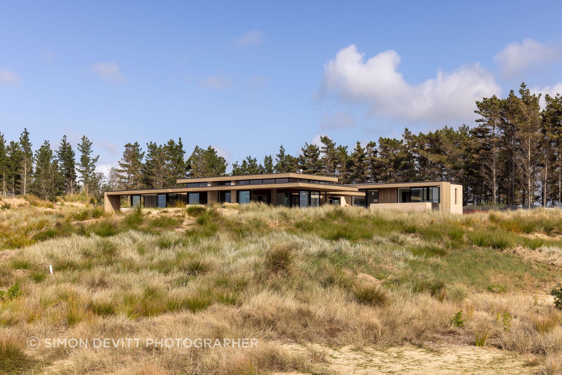 The Dune House crouches low in the sand dunes.