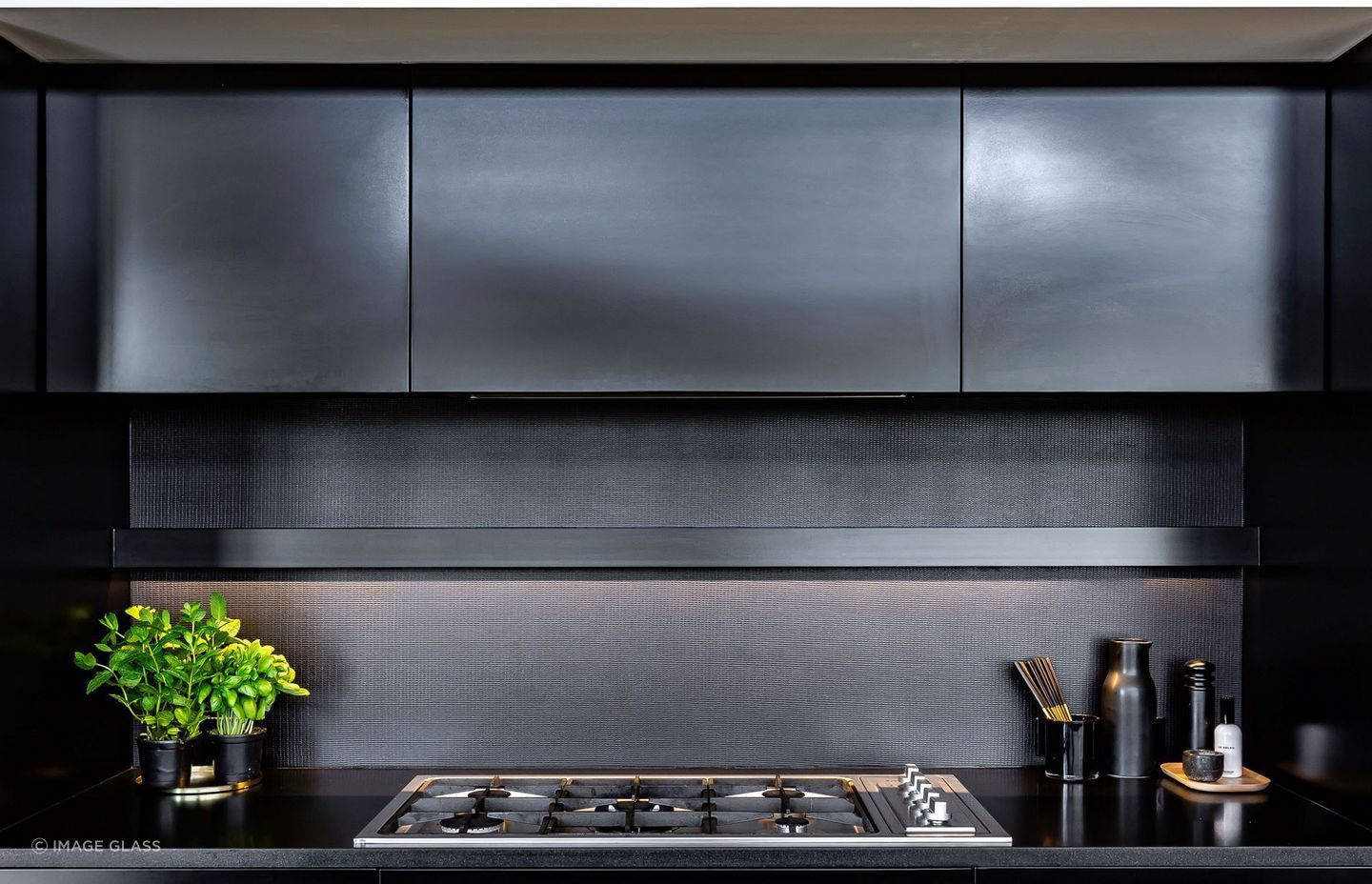 The metal coated glass splashback in this Remuera kitchen is bold, robust and contemporary.