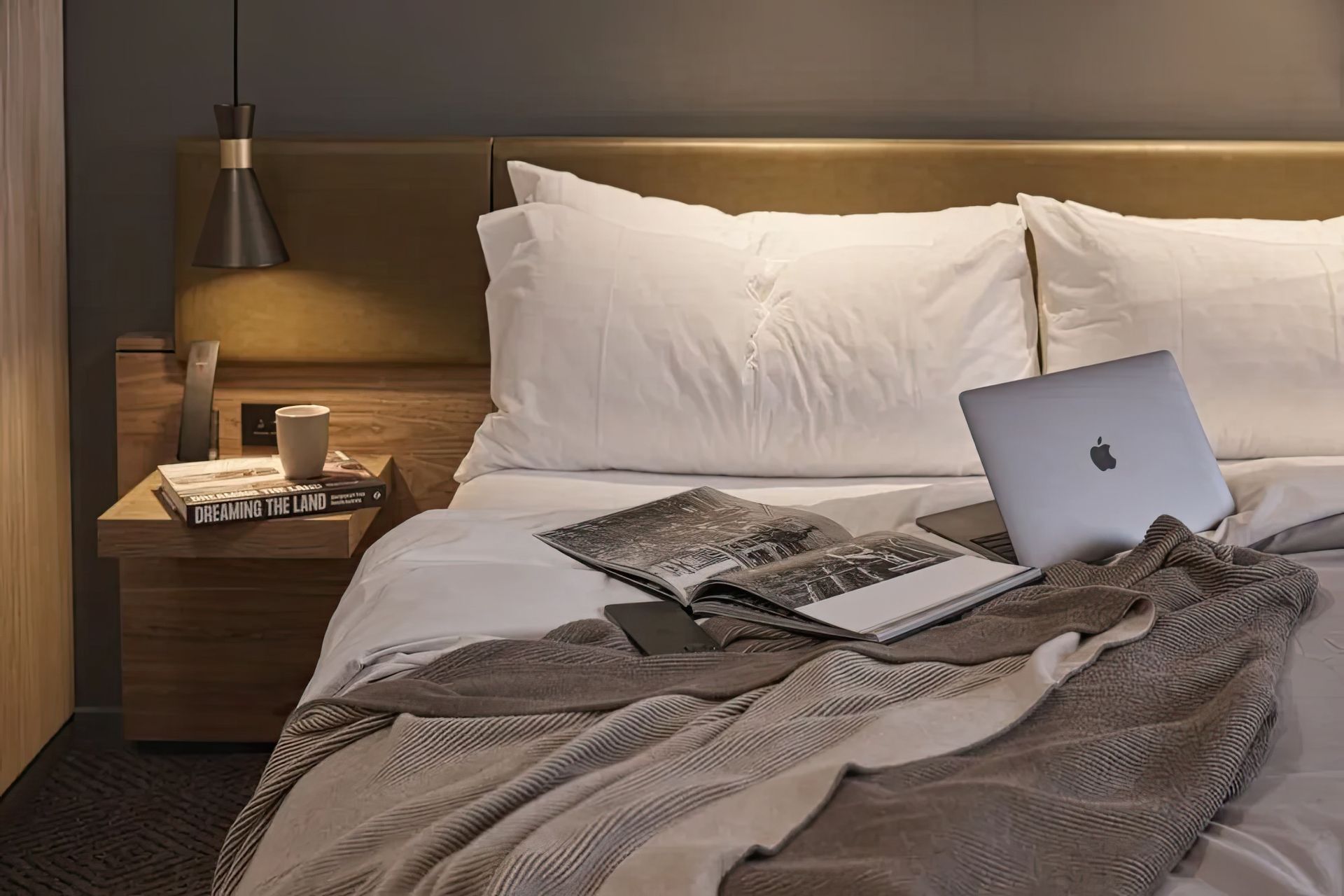 Bemboka percale duvet and reversible rib cotton throw styled in a moody, layered bedroom at Rydges, Melbourne.
