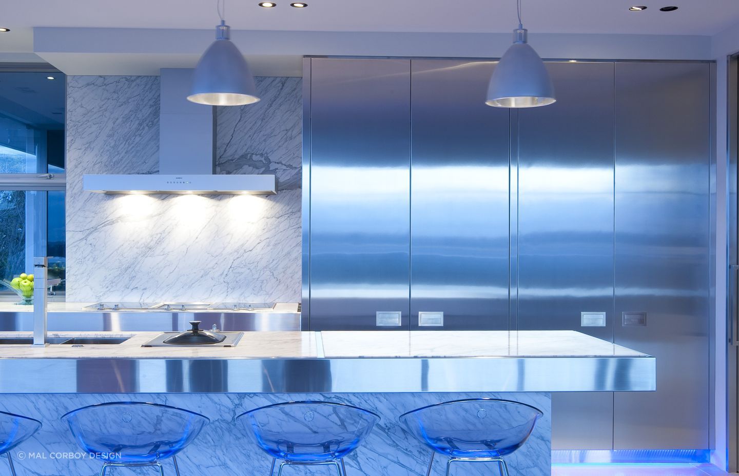 Stunning floor to ceiling stainless steel kitchen cabinets make a big impact in this modern St Stephens Apartment by Mal Corby Design.