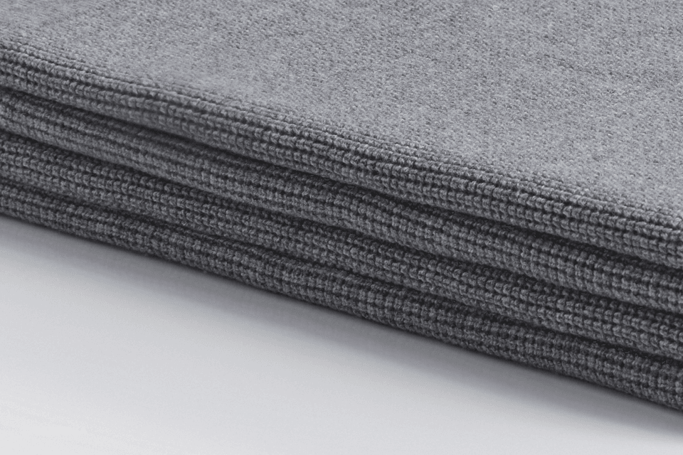 A close-up view of the Bemboka Ultrafine Merino Small Box Throw in shade Pale Grey, showcasing the luxurious softness and intricate weave of fine merino wool fibers.