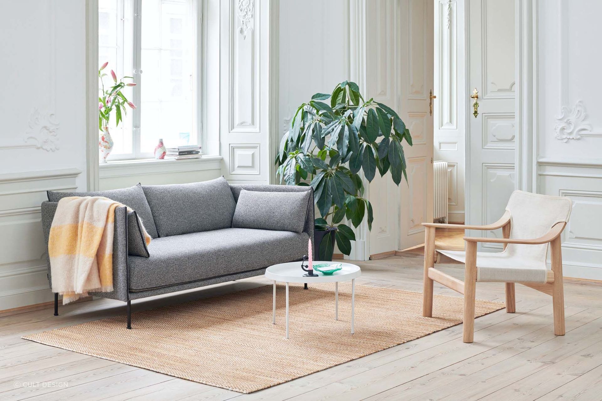 The inclusion of plants can bring freshness and vitality to a living space, seen here alongside the chic Silhouette Sofa by Hay.