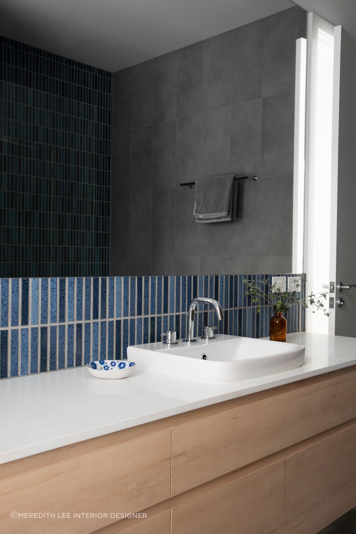 Tiles that incorporate different shades of blue are an easy way to bring a coastal theme to a bathroom.