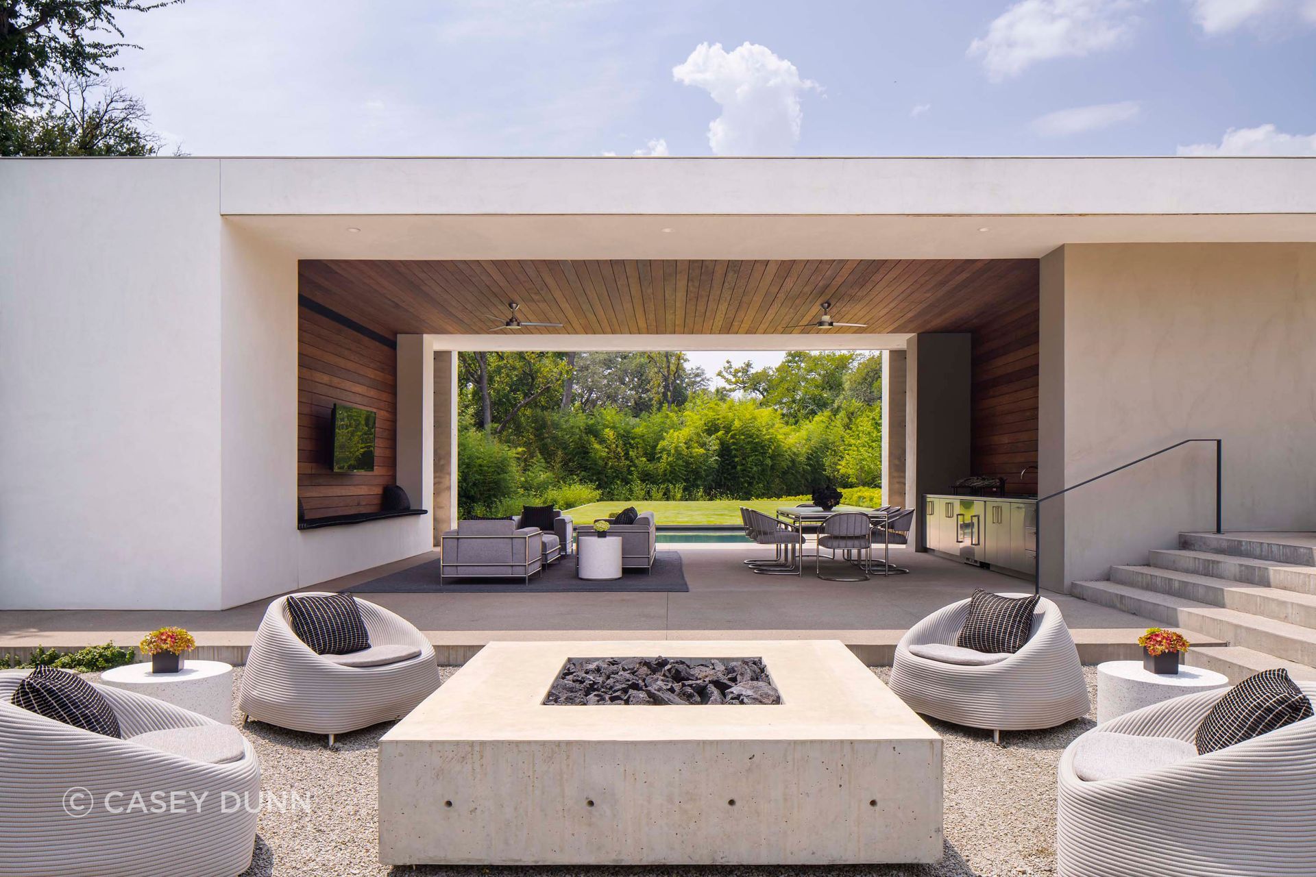Concrete is used beyond structure at Preston Hollow, helping define outdoor rooms, frame movement through the home and create a continuous relationship between interior, courtyard and landscape.