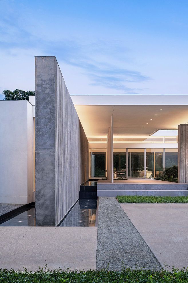At Preston Hollow Residence, the concrete spine walls extend from inside to out, giving the home structure, privacy and a strong architectural rhythm.