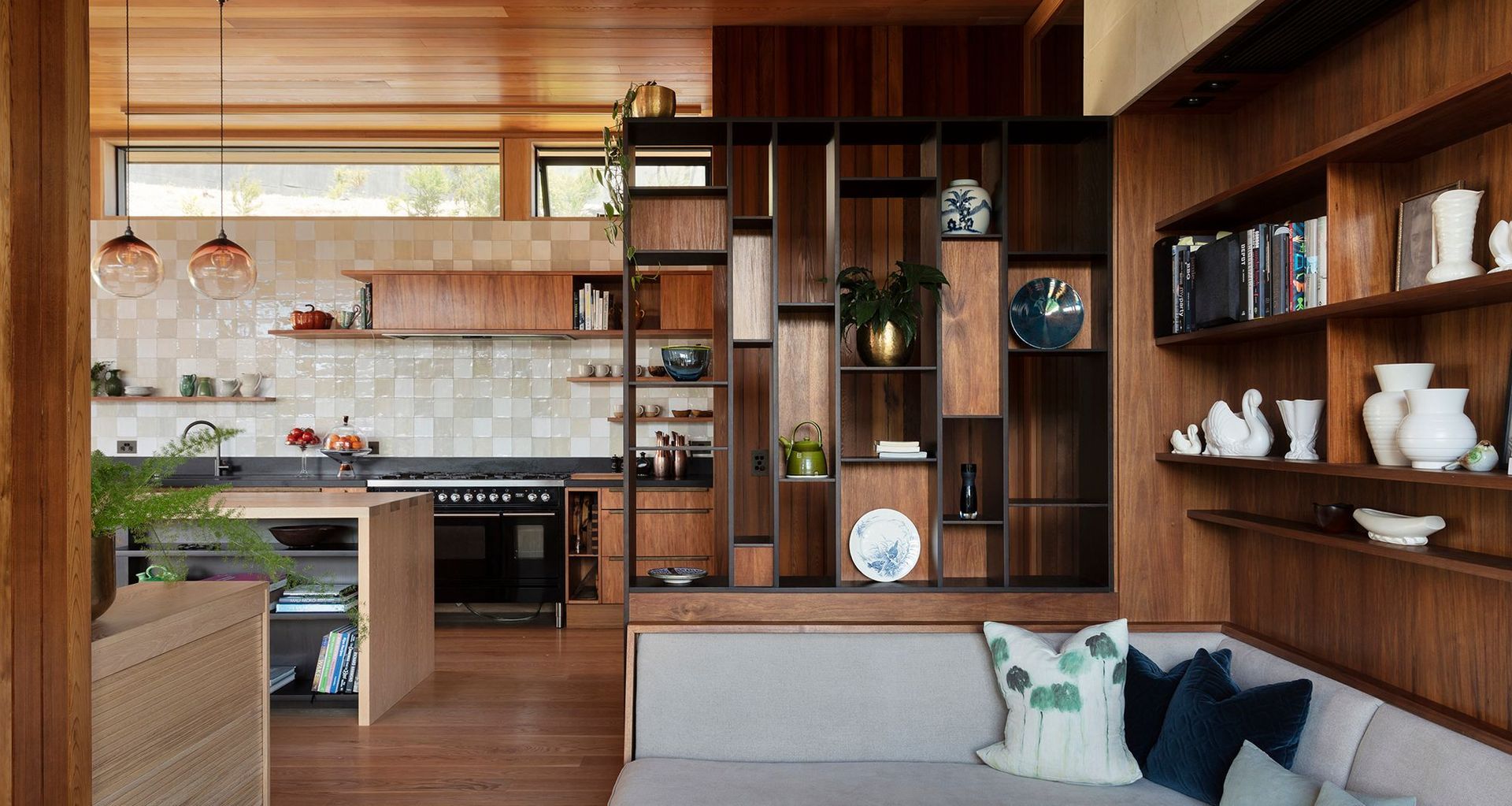The Knoll by Megan Edwards Architects uses a cabinetry screen and floor level changes to delineate different zones within an open plan.