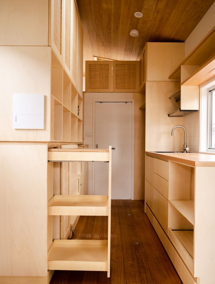 This tiny house features clever space-saving cabinetry by Ilm Interiors.