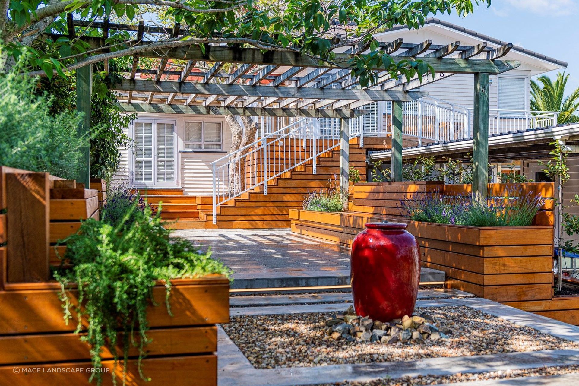 A water feature, like the one featured in this lovely home in Titirangi, can act as a strong focal point for an outdoor living space.