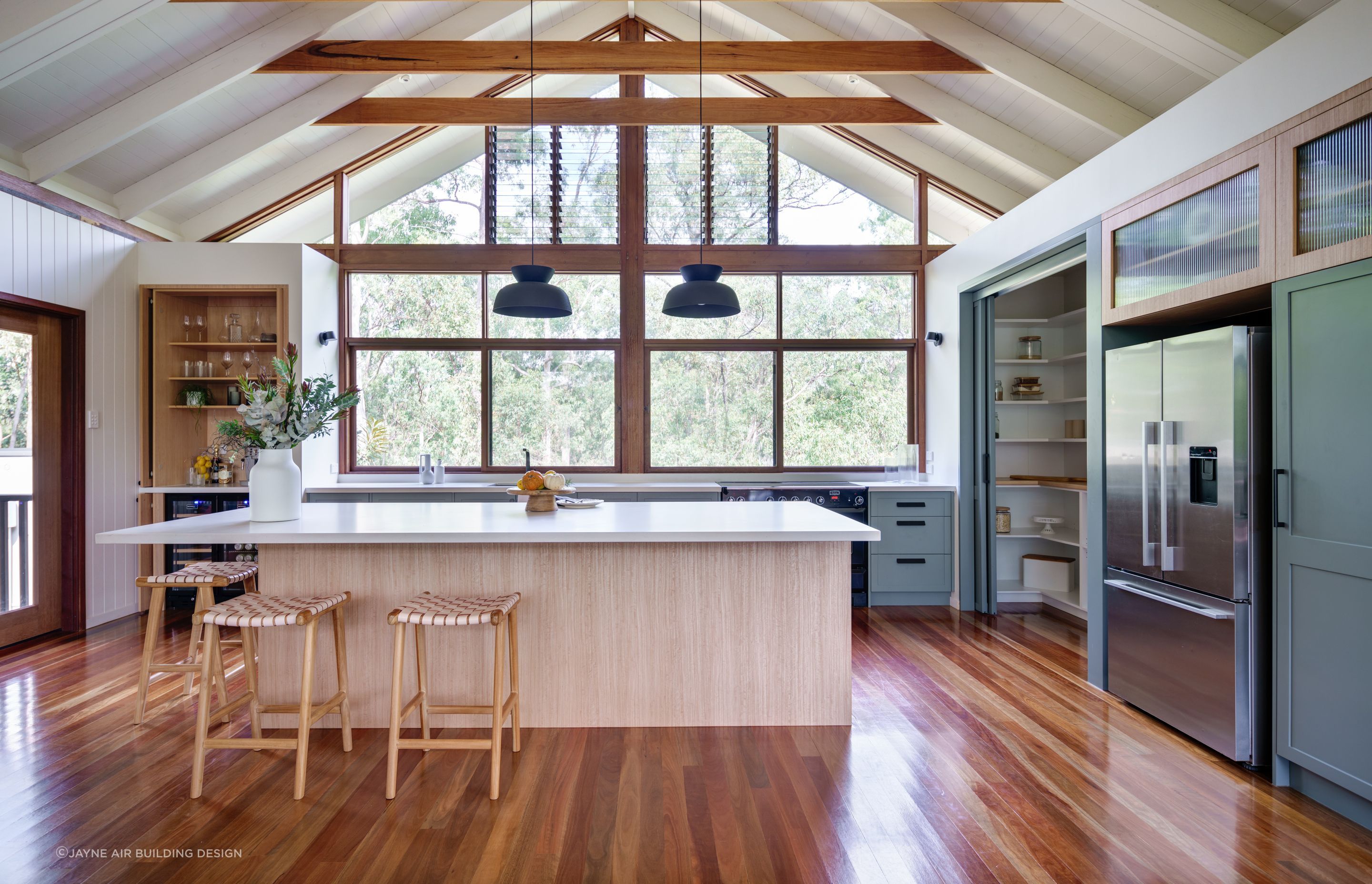 Expansive kitchen windows allow abundant natural light to fill a space, helping to cut down on energy bills while offering great scenic views. Photography: Alan Bouvier.