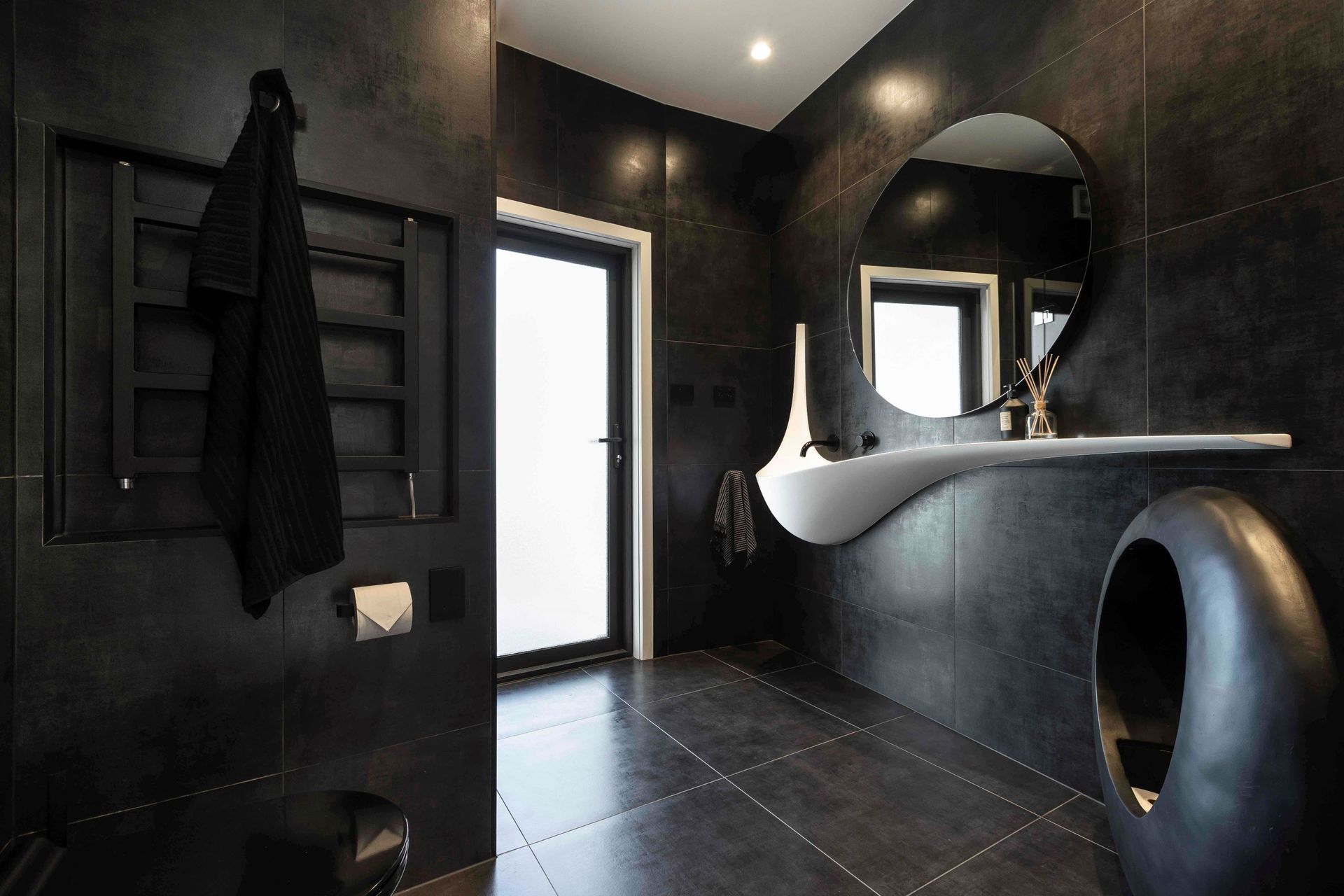 Modern bathroom designs, like this stylish black bathroom in Wiri, are much more daring with their colour schemes.