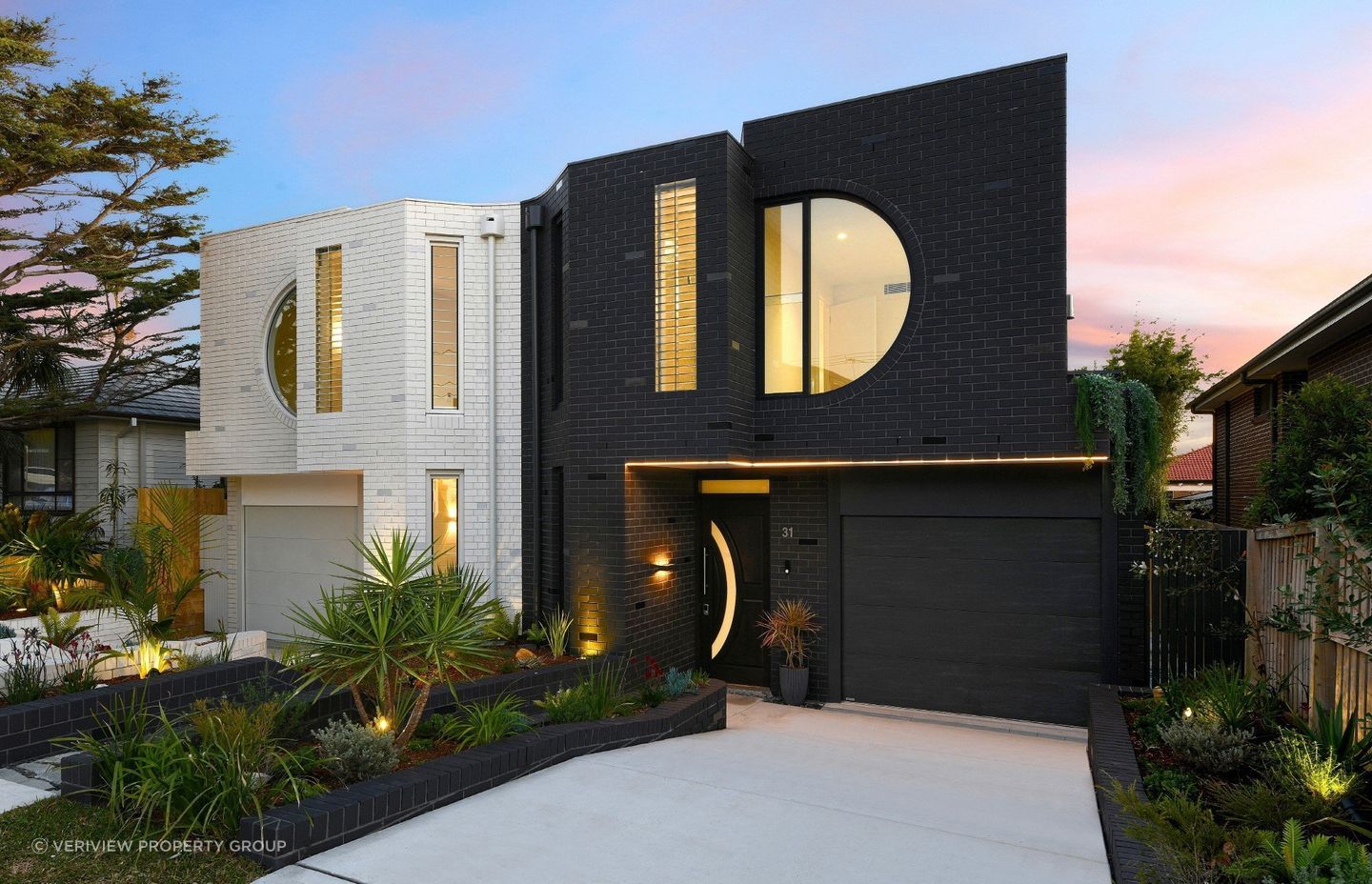 The front door of this home complements the property's architectural lines, with its round window matching the building's circular design elements. Featured project: Duality by Veriview Property Group