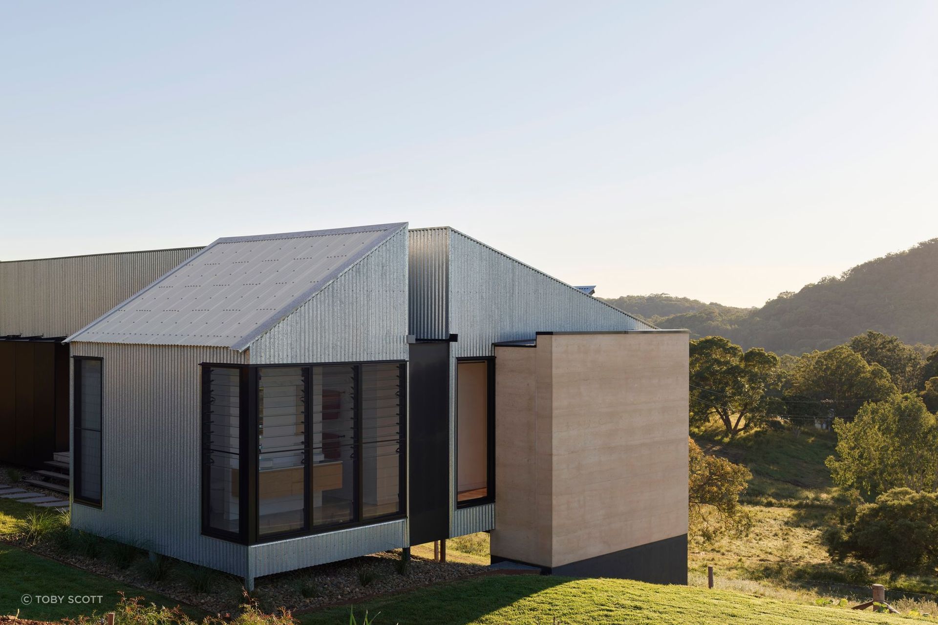 Andy’s House by Robinson Architects balances sustainability with softness, using rammed earth, timber and breezes to create a calm, low-energy home | Photography by Toby Scott