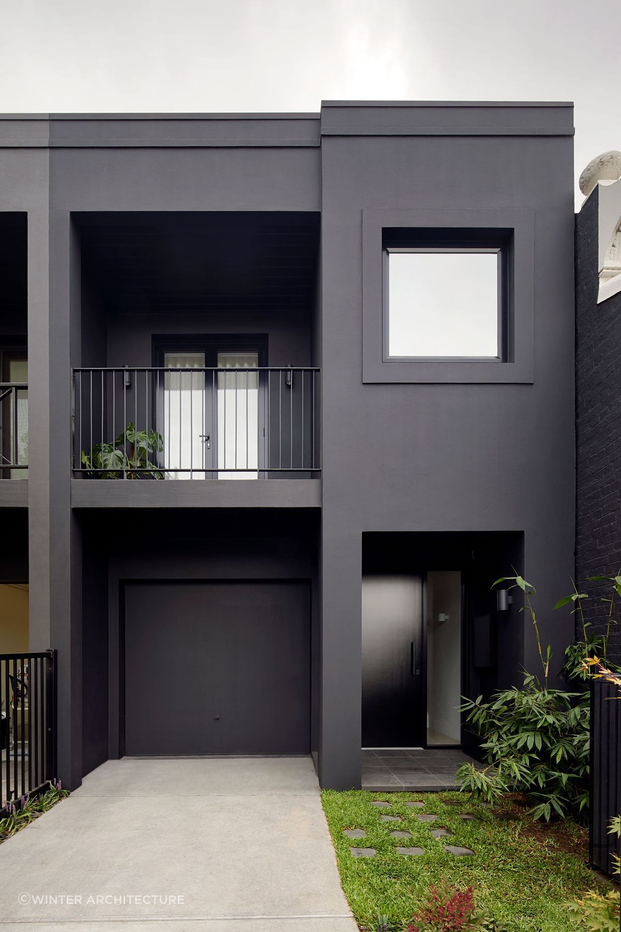 A sumptuous matte black door punctuates the entrance of this South Yarra townhouse, providing a striking contrast to the textured facade. Featured project: South Yarra Townhouse by Winter Architecture