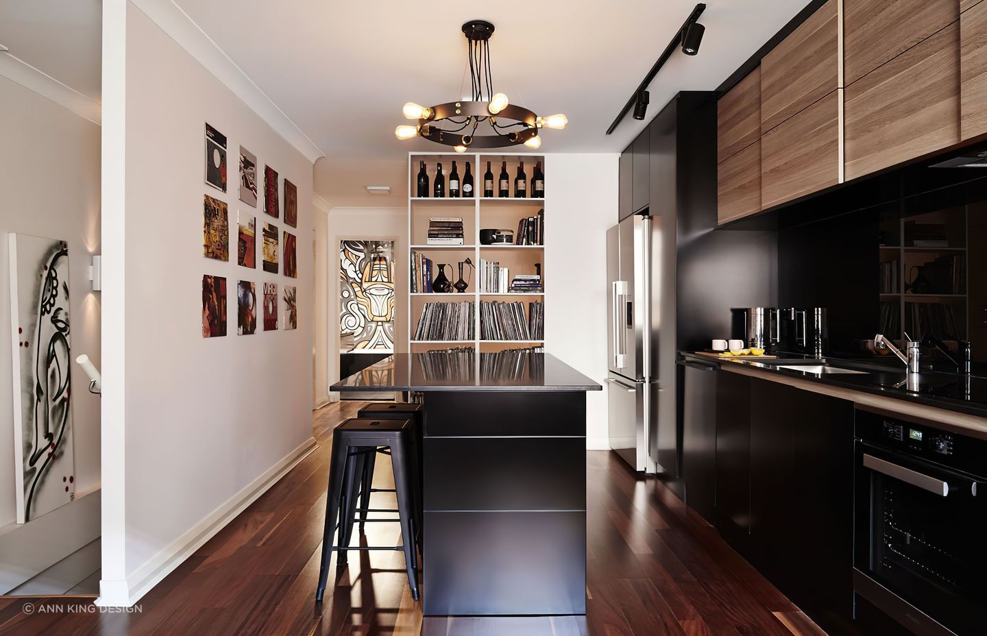 The lighting fixture in this kitchen matches the worktop style and compliments the wall art and record sleeves placed on the wall.
