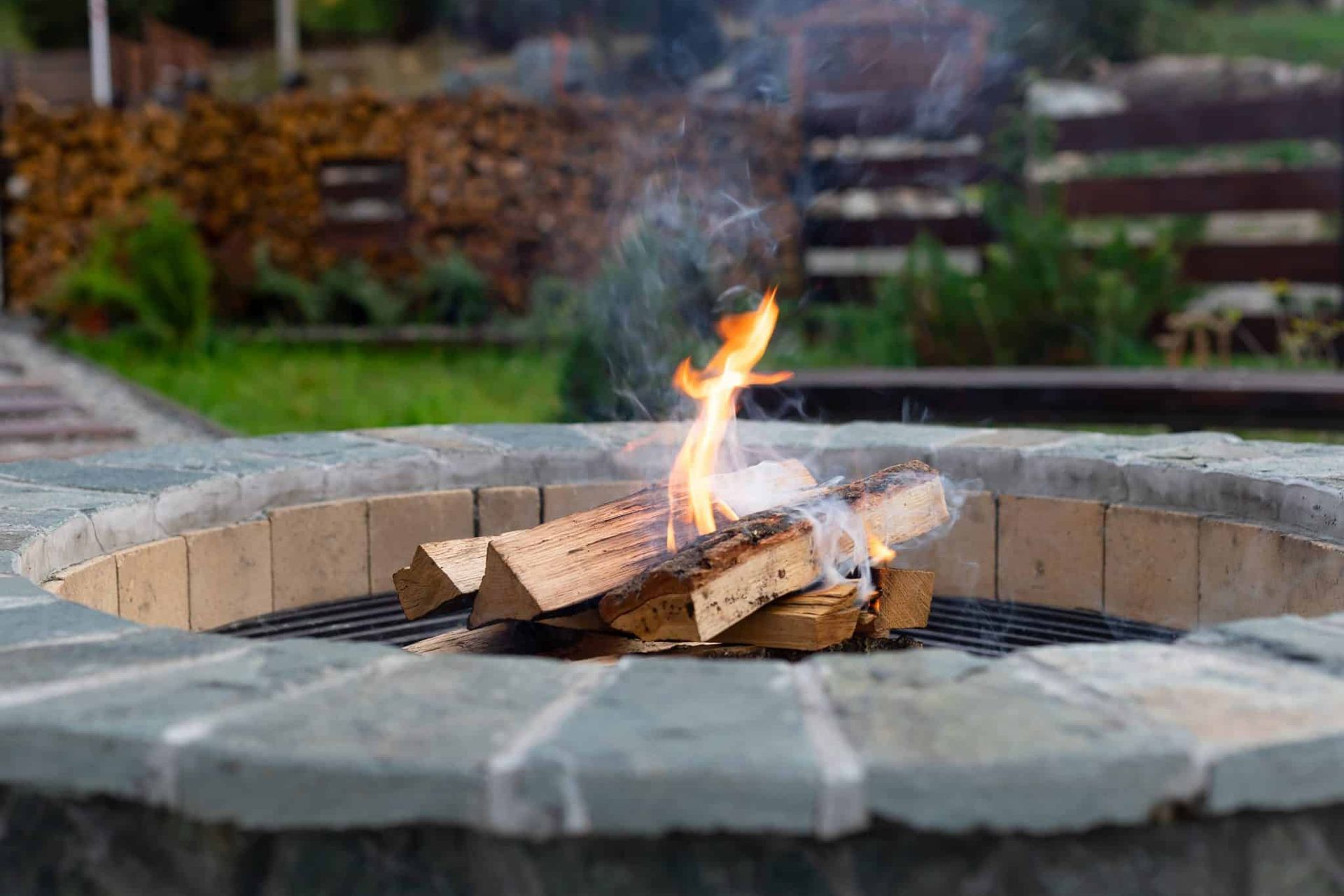 zone-relax-with-burning-fire-pit-couch-against-lawn-wood-fence-rest-relaxation-concept-2048x1395.jpg