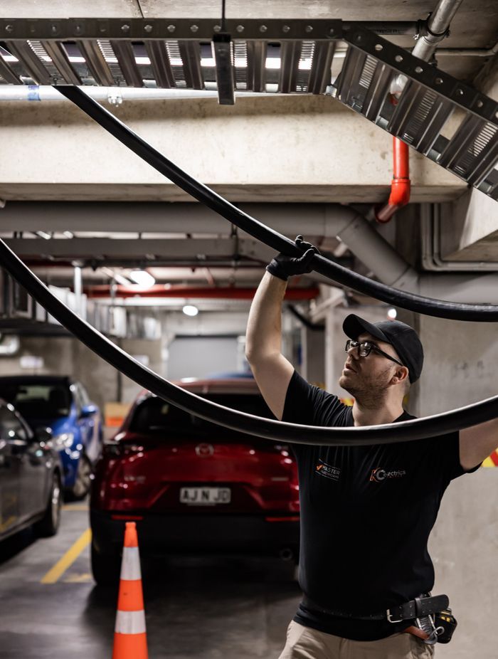 A K C Electrics team member installs distribution switchboard mains cabling.