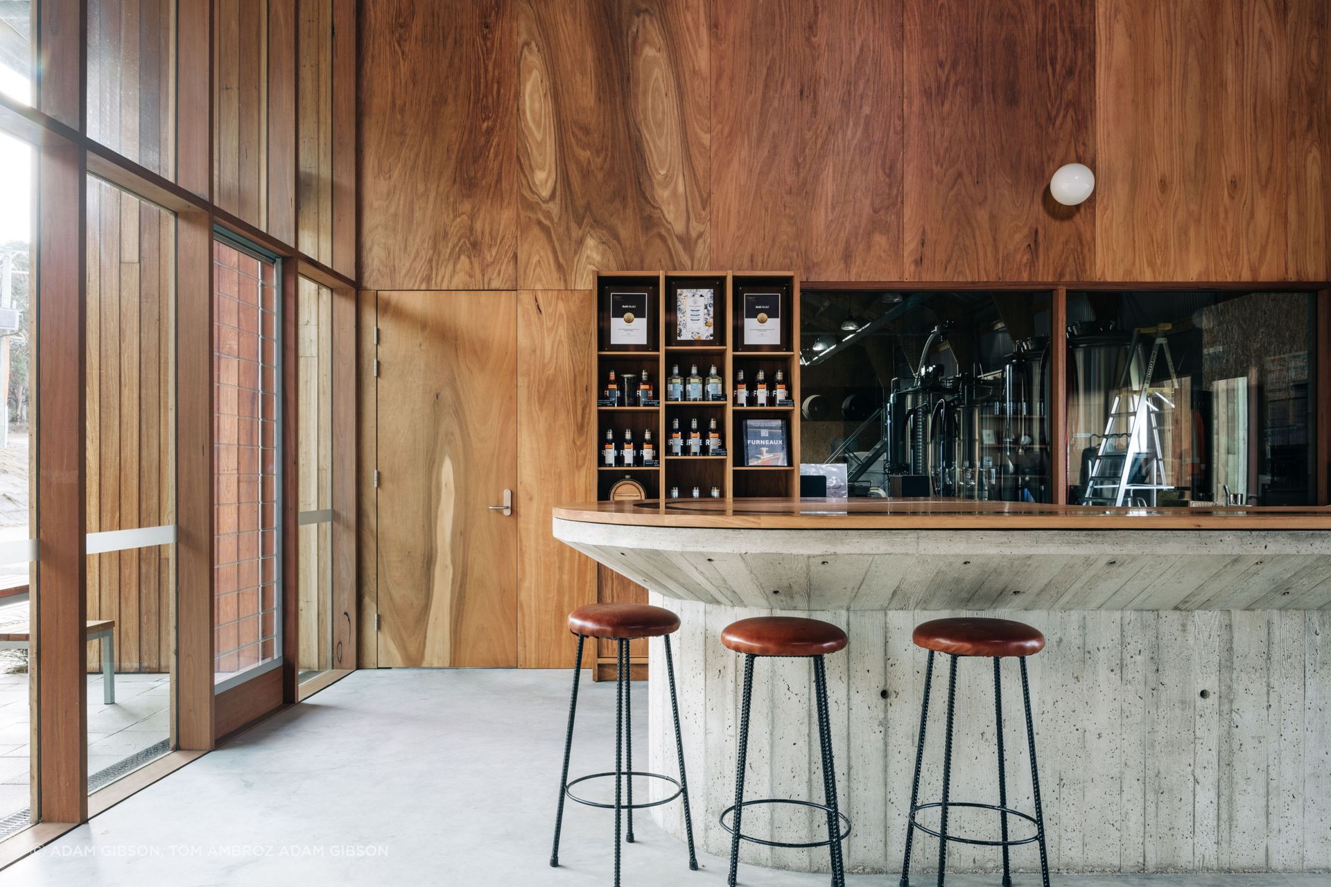 The material palette used throughout the Furneaux Distillery is an intentional blend of natural timber and industrial concrete lending tactile warmth.