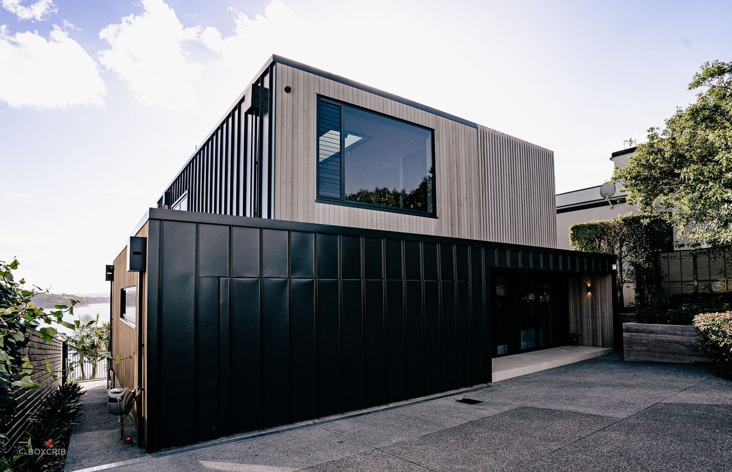 The entrance of the house showcases the two primary cladding materials used for the home.