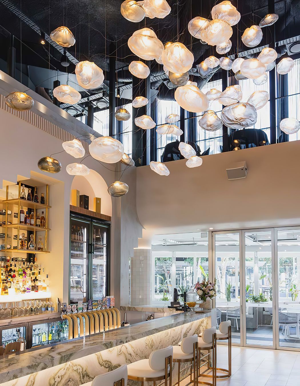 The largest Bocci commission in Australia to date, the cluster of 61 hand-blown Bocci 73 Series glass lights transform the Blowfish Ocean Grill + Bar on the Gold Coast designed by Space Cubed Design Studio. Photography by Harley McNamee courtesy of Bocci