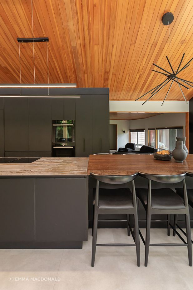 The variation in benchtop materials adds contrast and texture, visually dividing the dining area from the kitchen work zone.