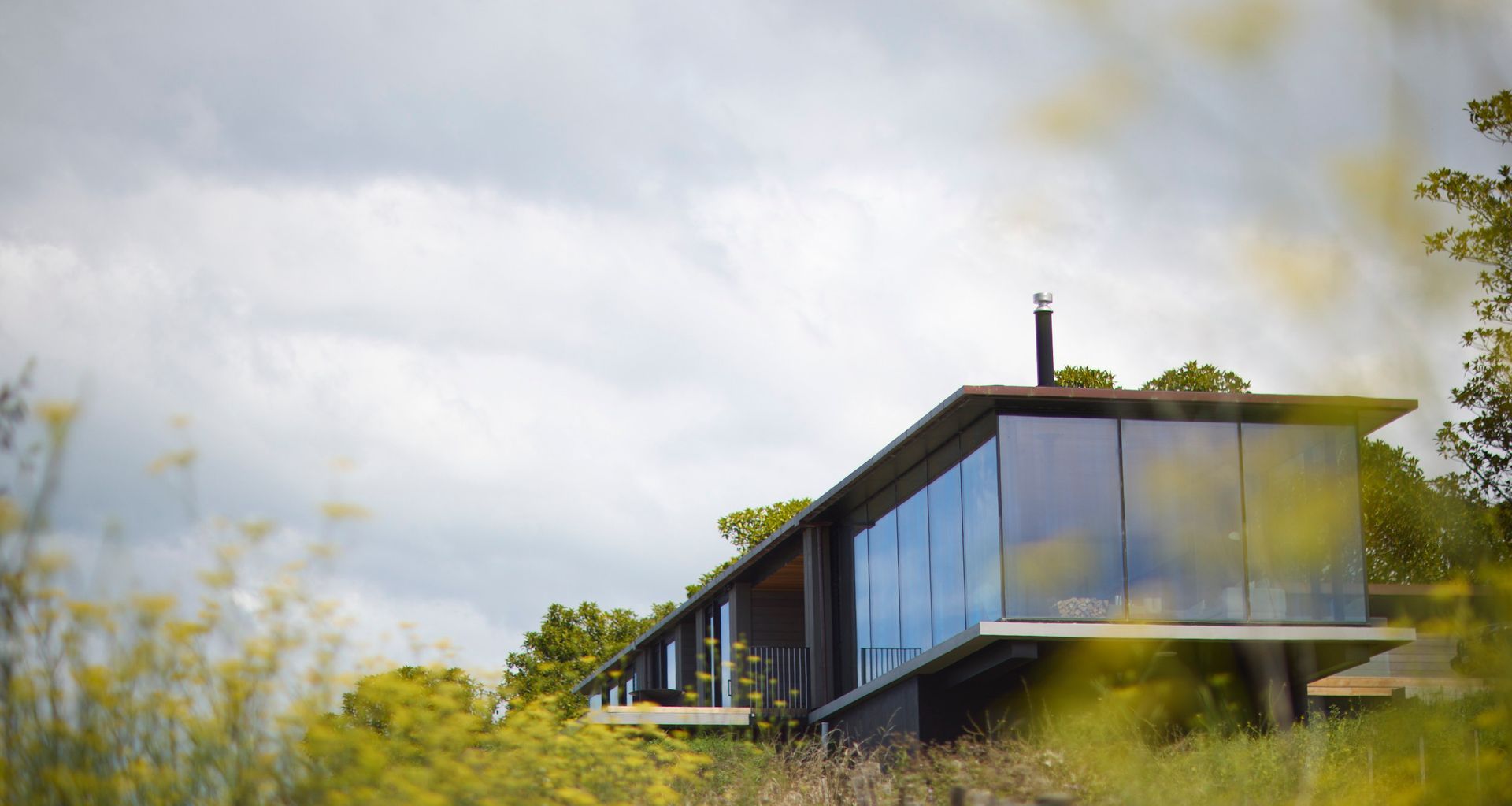 Tākapu by Daniel Marshall Architects sits just below the ridge above Ocean Beach, its linear form shaped by outlook, shelter and the force of the southwest wind.