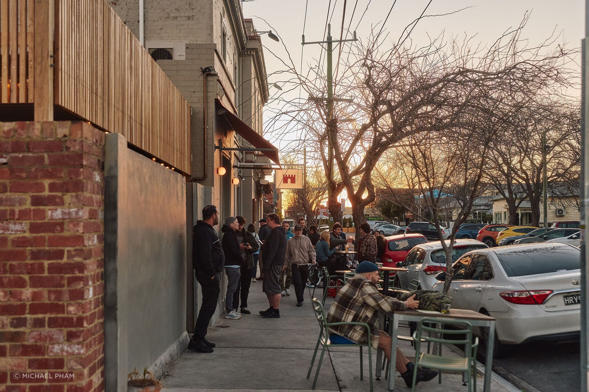 Locals spill out onto the street outside Mona Castle at Golden hour on a Saturday afternoon.