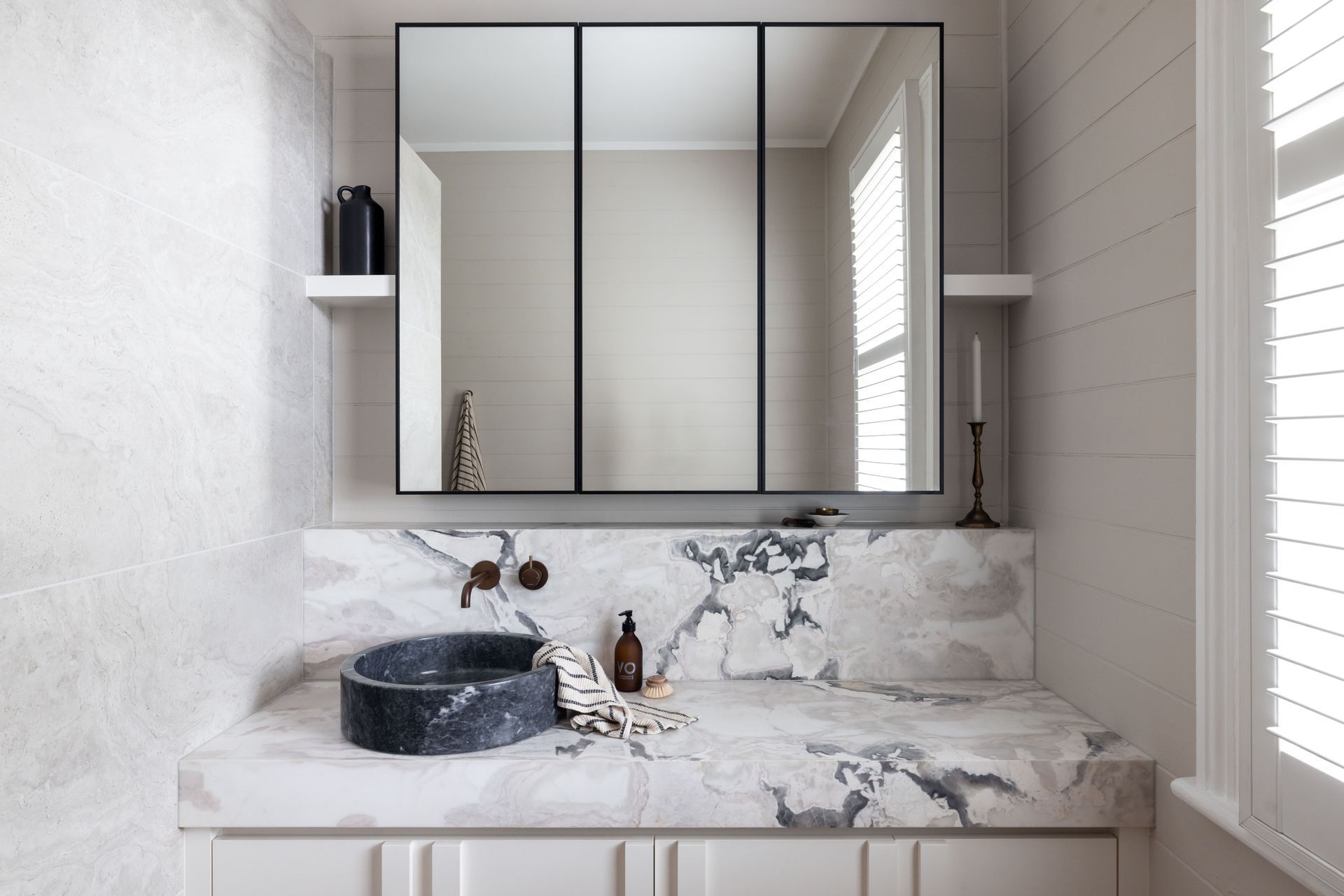 The blue stone basin and marble vanity top in this bathroom in Puriri shows the difference high-quality materials can make - Photography: Jono Parker
