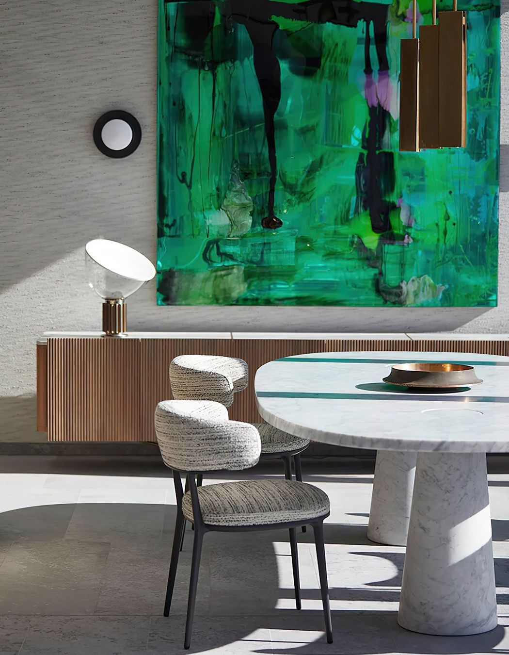 Against the backdrop of a vibrant green Dale Frank painting and Sydney Harbour, the Agape Casa dining table designed by Angelo Mangiarotti in cool grey Carrara marble, the Caratos upholstered dining chairs designed by Antonio Citterio for Maxalto, the iconic Taccia table lamp designed by Giacomo and Achille Castiglioni for Flos, the Bell Sconce wall light designed by Post Company for Roll & Hill, and the Charlotte low cabinet designed by Carlo Colombo for Giorgetti. Photo © Martin Mischkulnig