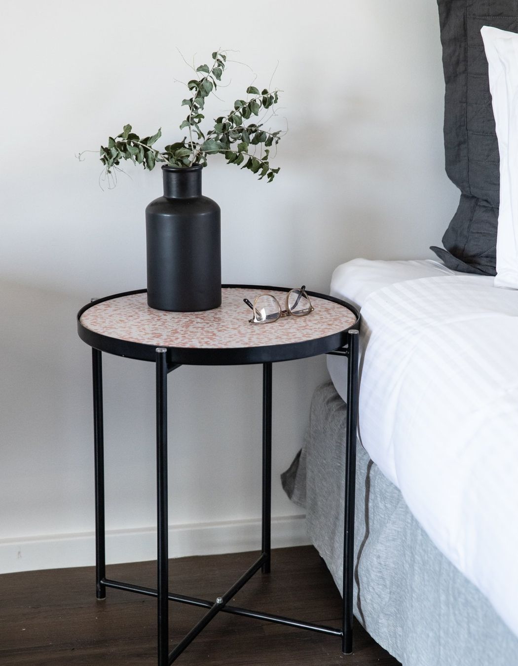 This Round Side Table works as a functional nightstand.