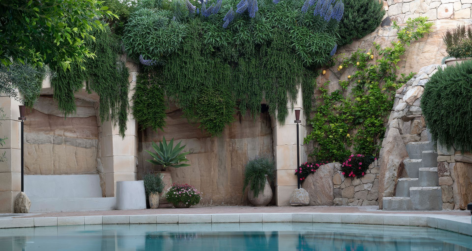At One of a Kind, a Mediterranean-inspired planting palette and extensive stonework create a garden shaped by the client’s travels, the character of the site and the architecture around it.