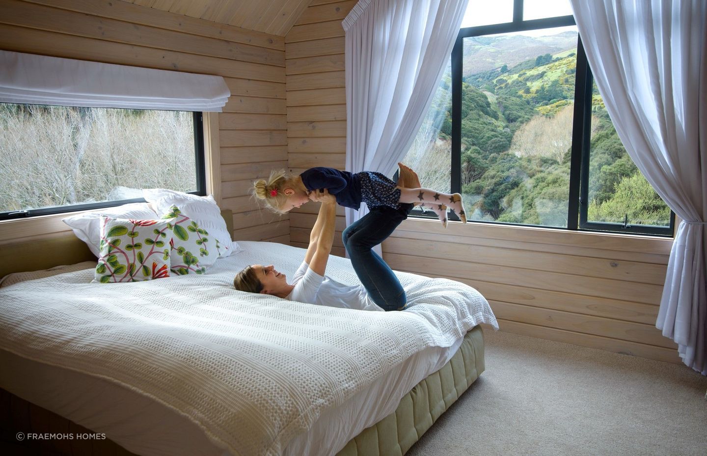 A neutral colour palette, as well as shades of green and blue, can create calming vibes in a bedroom, seen here in the stunning Split Level Timber Home on a Hill project in Tai Tapu