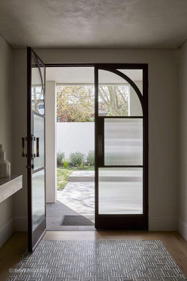 Square steel mullions were incorporated on the entry doors to complement the hallway archway.