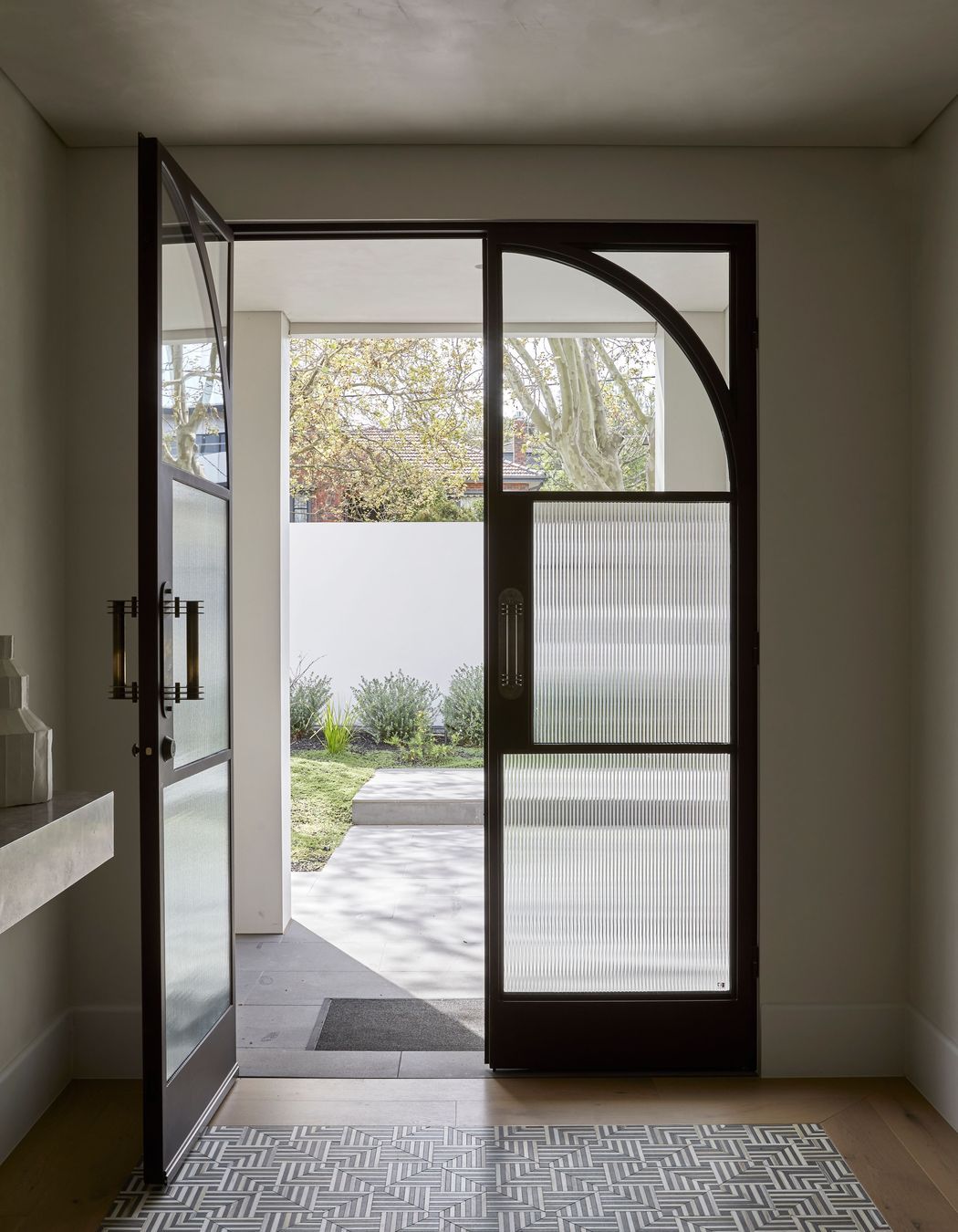 Square steel mullions were incorporated on the entry doors to complement the hallway archway.