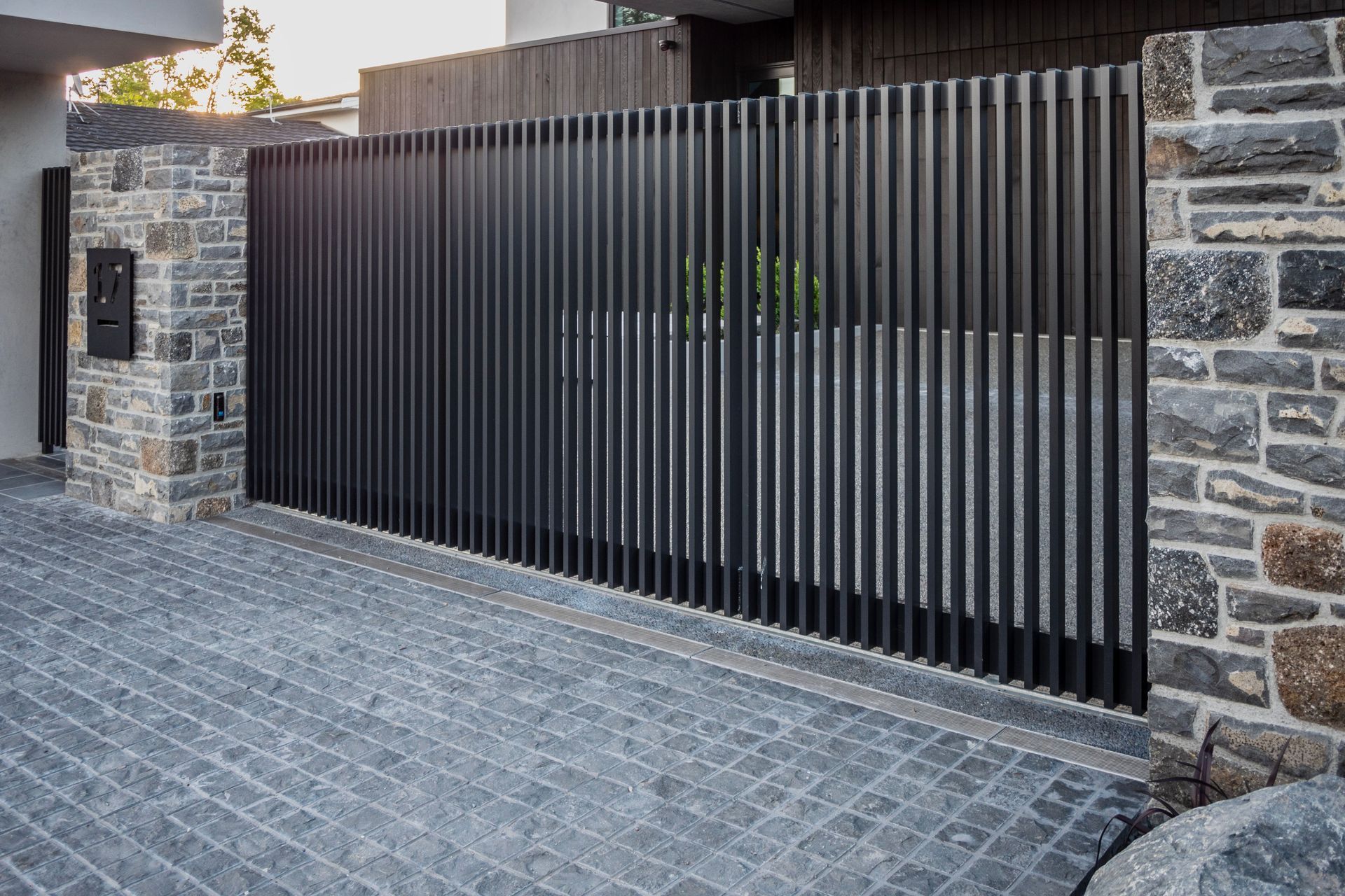 The sliding drive gate is automated and equipped with safety beams.