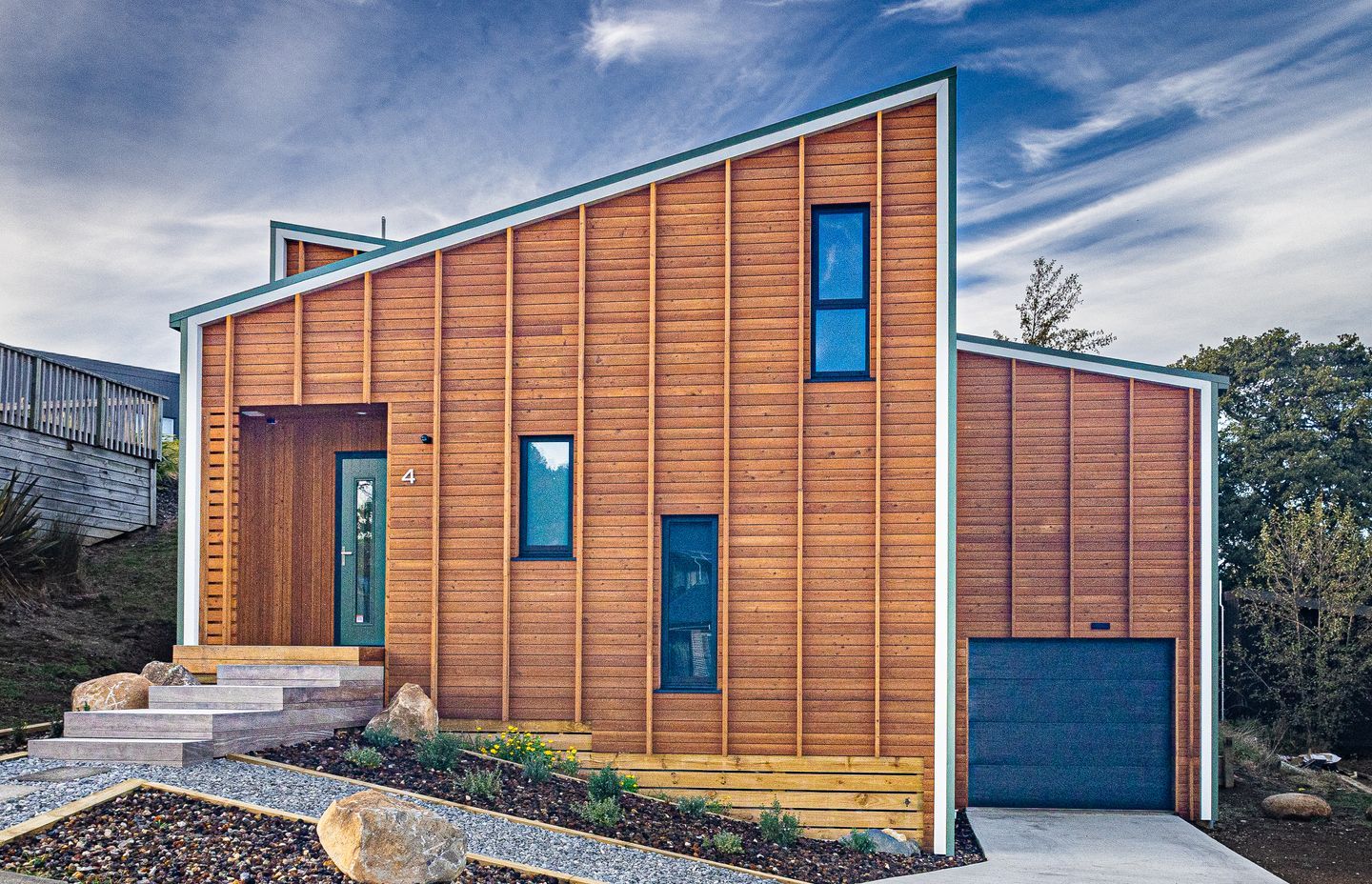 Vertical battens over larch weatherboards accentuate the height of the house.