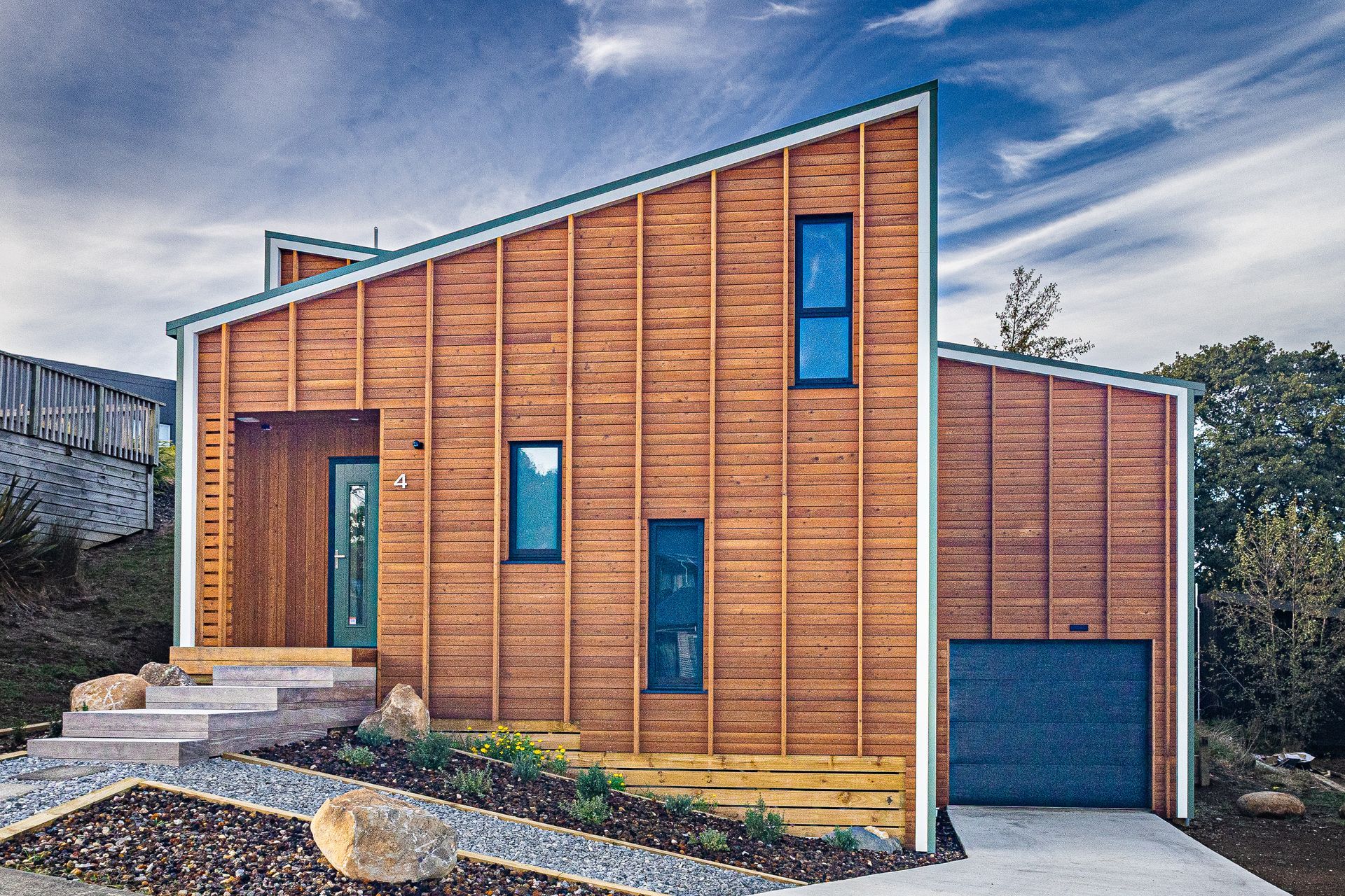 Vertical battens over larch weatherboards accentuate the height of the house.