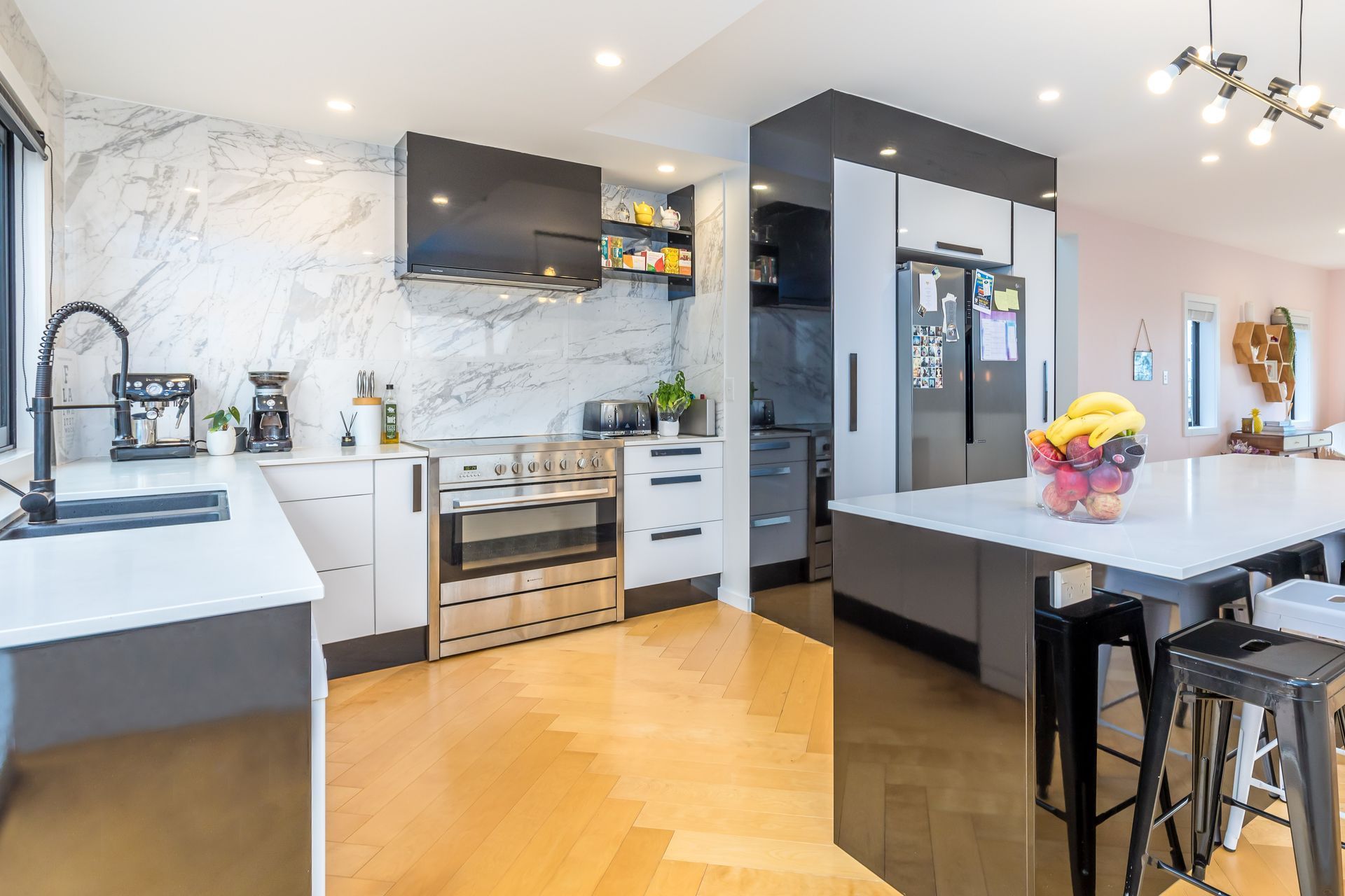 Installing the herringbone flooring was very time-consuming. Gloss tiles were taken full height in the kitchen for impact.