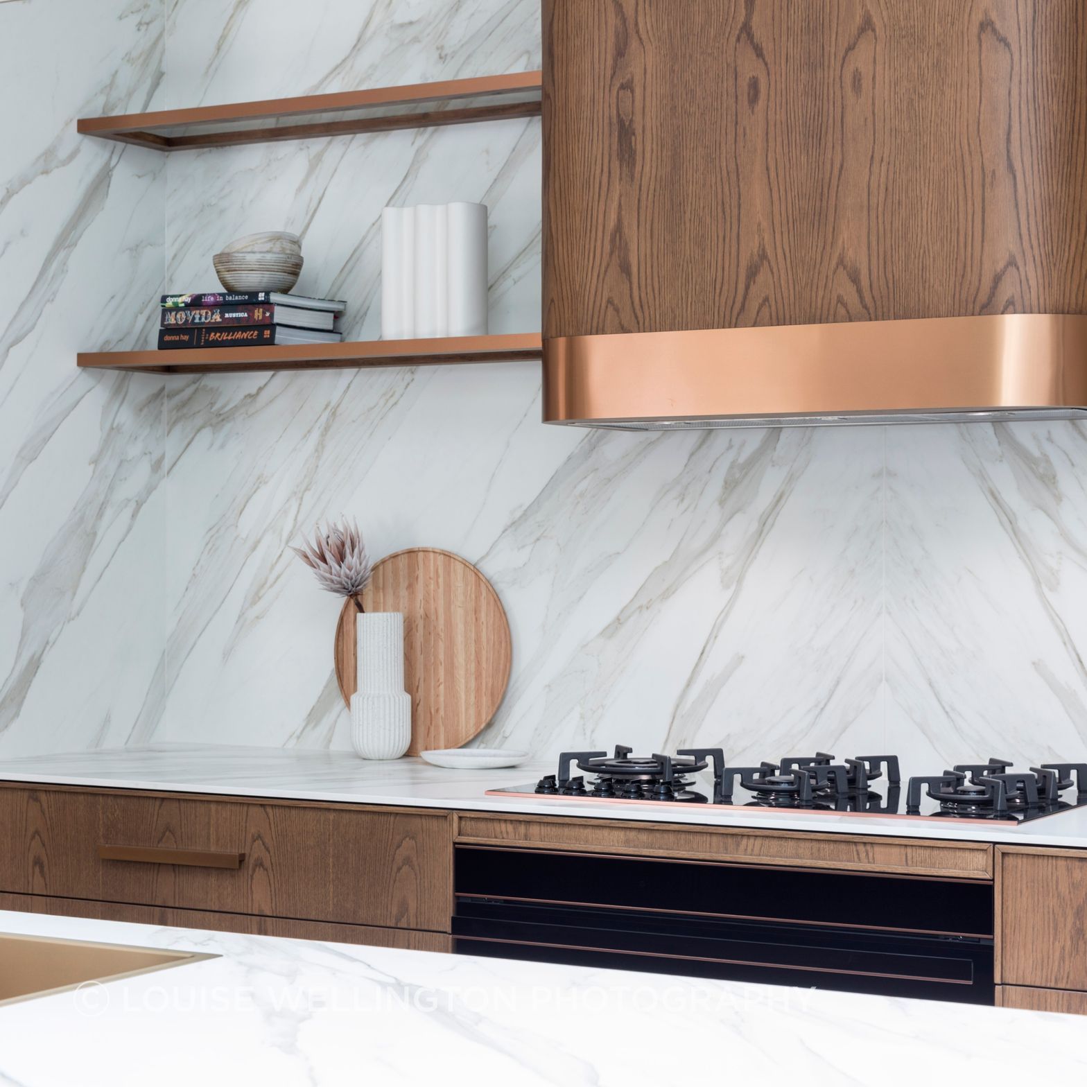 Oxford Project. Front of House kitchen wall features Neolith clad walls and Farmers Doors curved rangehood box, bronze metallic trims.