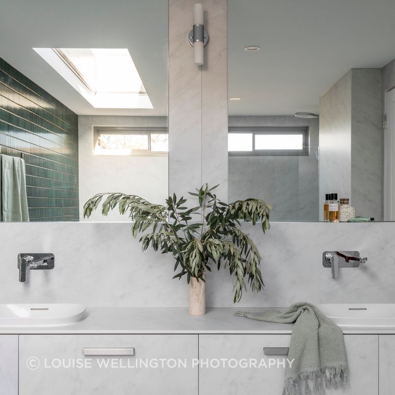 Oxford Project. A calm and considered bathroom with Neolith carrara clad walls, and vanity offsets the dramatic green tile wall.