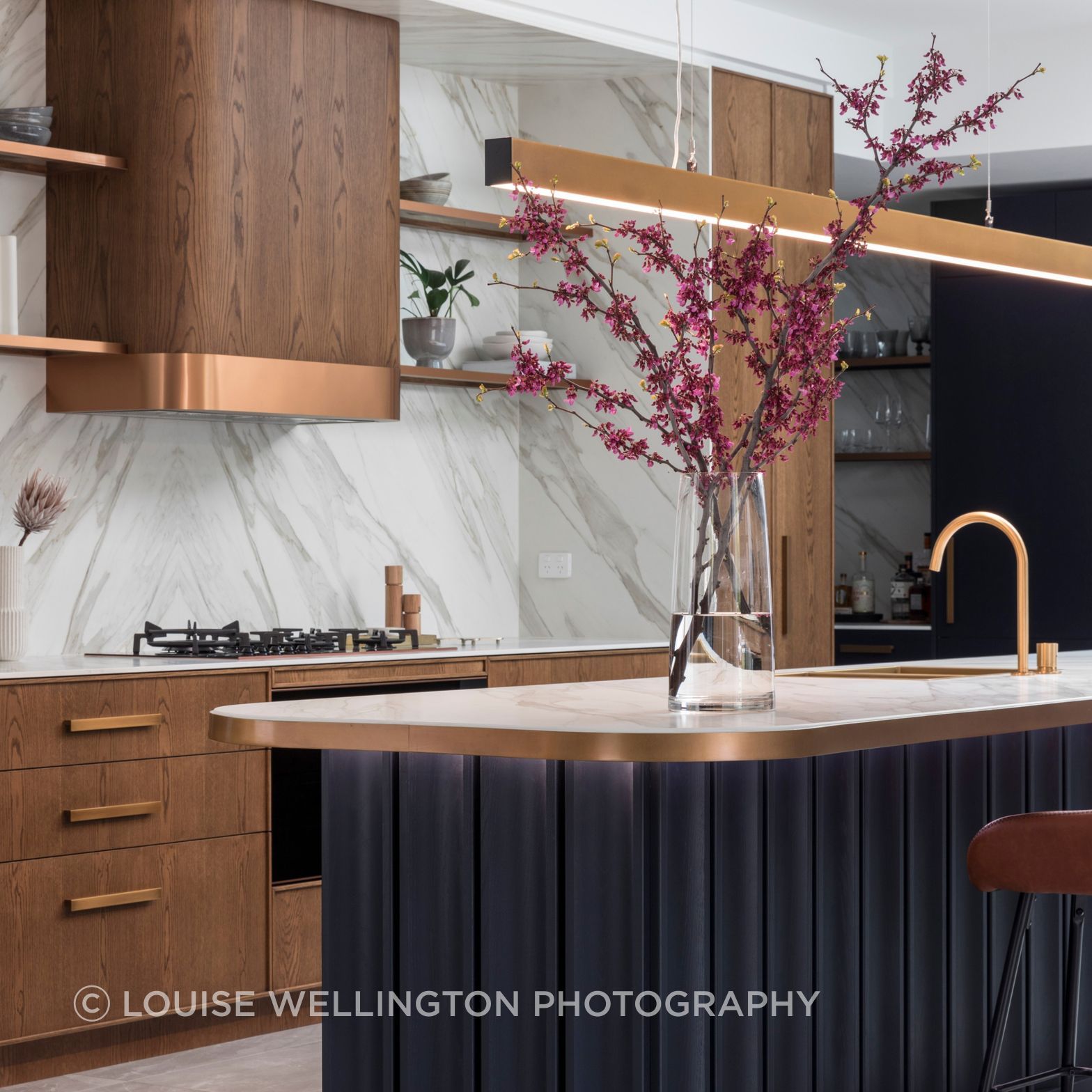 Oxford Project. The kitchen island is a statement in Farmers Doors deep blue timber veneer, warm teak and bronze metaillic detailing