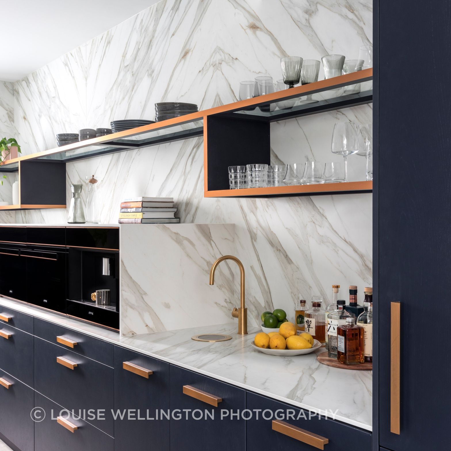 Oxford Project. The open scullery features Neolith clad walls and benchtops, cooking and bar zone with deep blue cabinetry and bronze metallic highlights