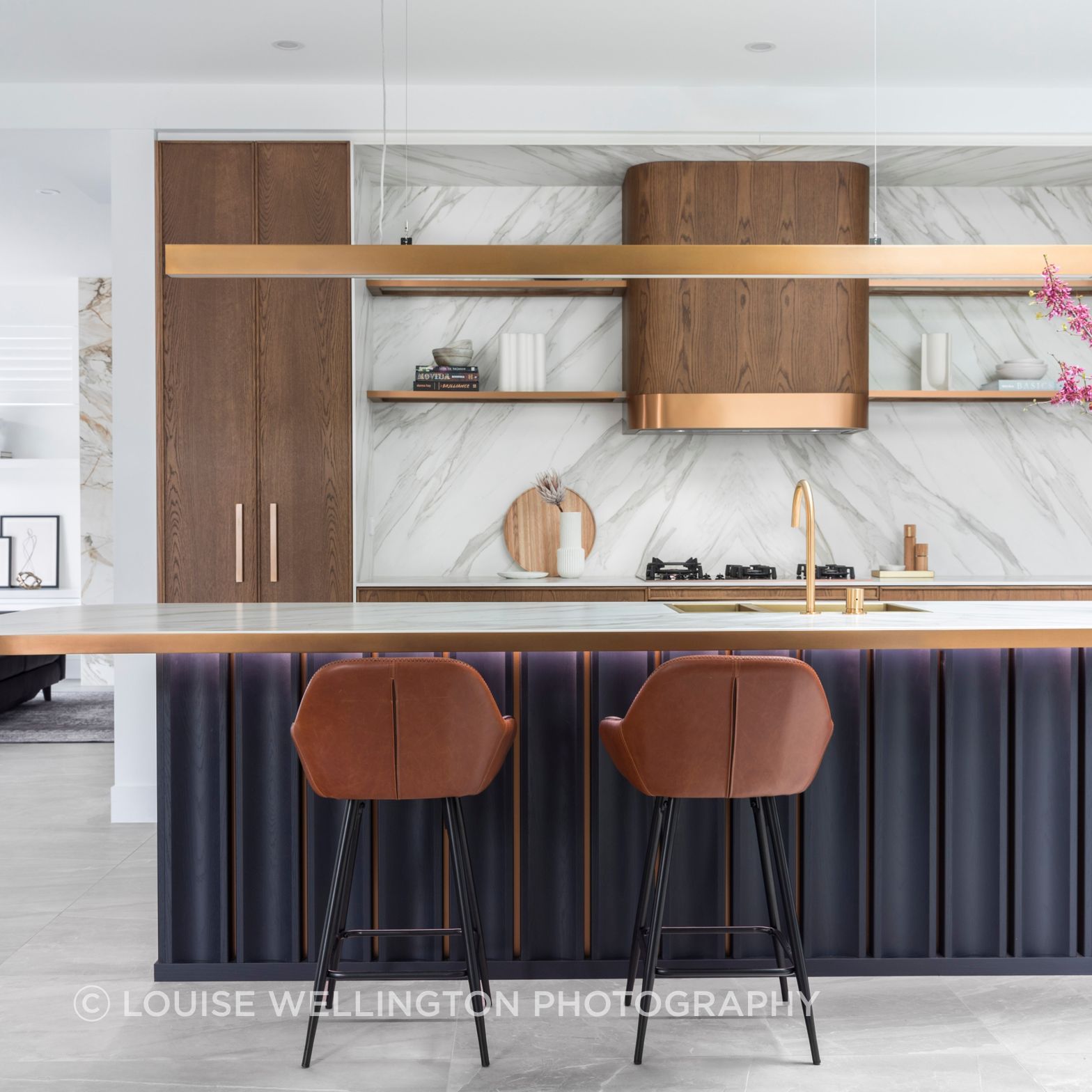 Oxford Project. Luxury kitchen design, award winning home. Features Neolith stone, Farmers Doors teak timber, curved rangehood and deep blue veneer.