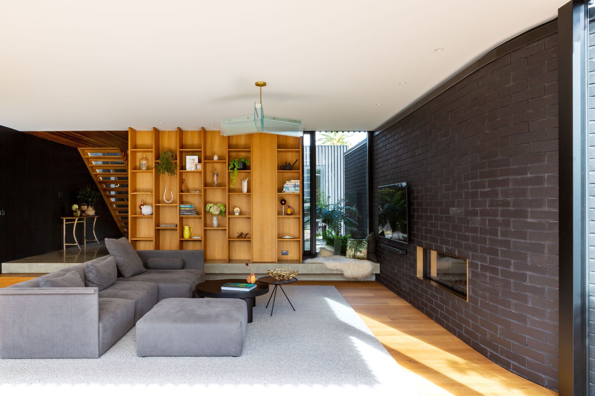 The concrete floor of the foyer steps down into the living room, to increase the room height, and the negative detail underneath has LED lighting. The cosy corner looks out to the entry courtyard. “With underfloor heating, it's slightly warm,” says Rina.