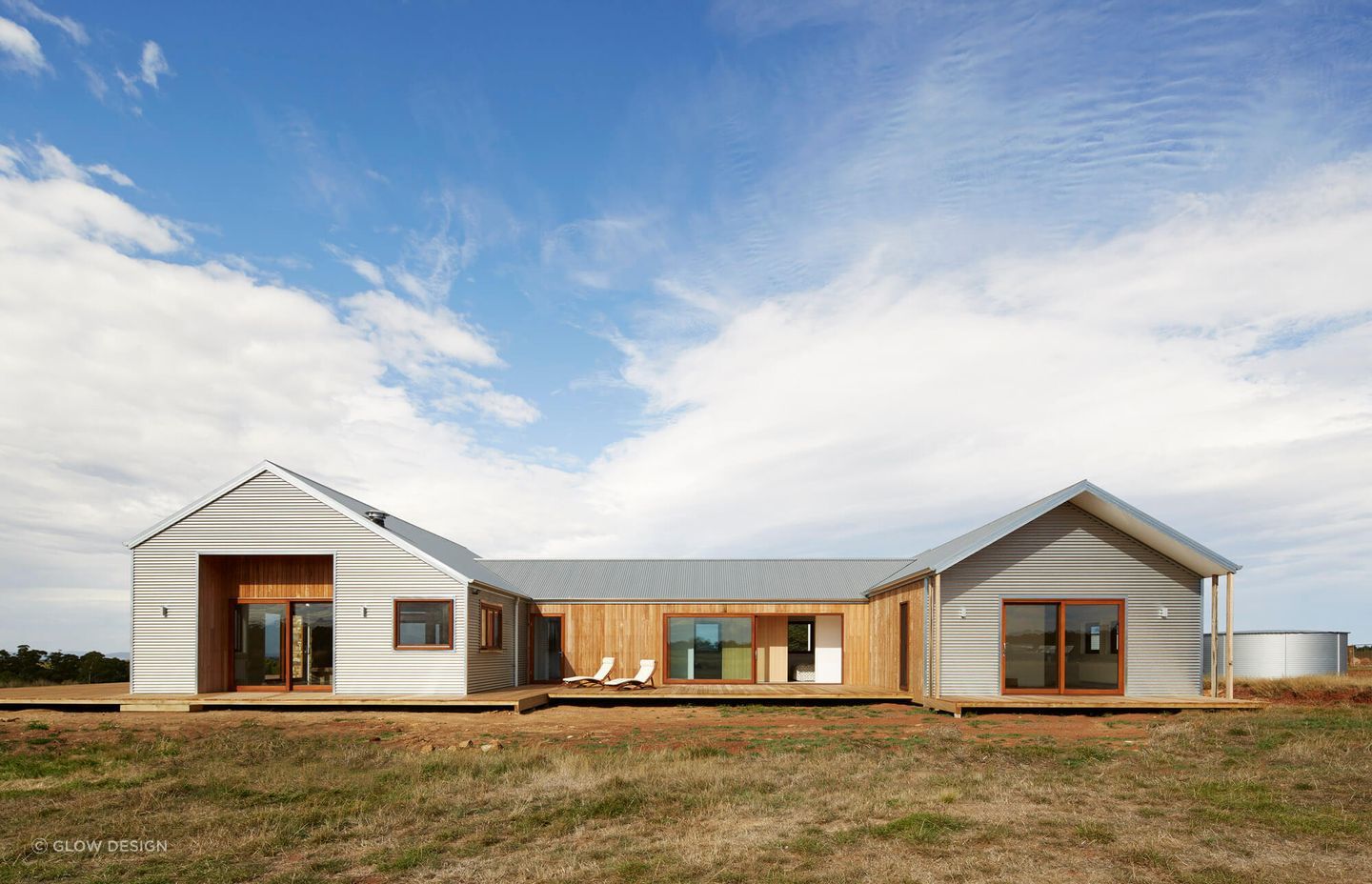 The pitched roof is designed for effective water collection into the tank, supporting sustainable living.