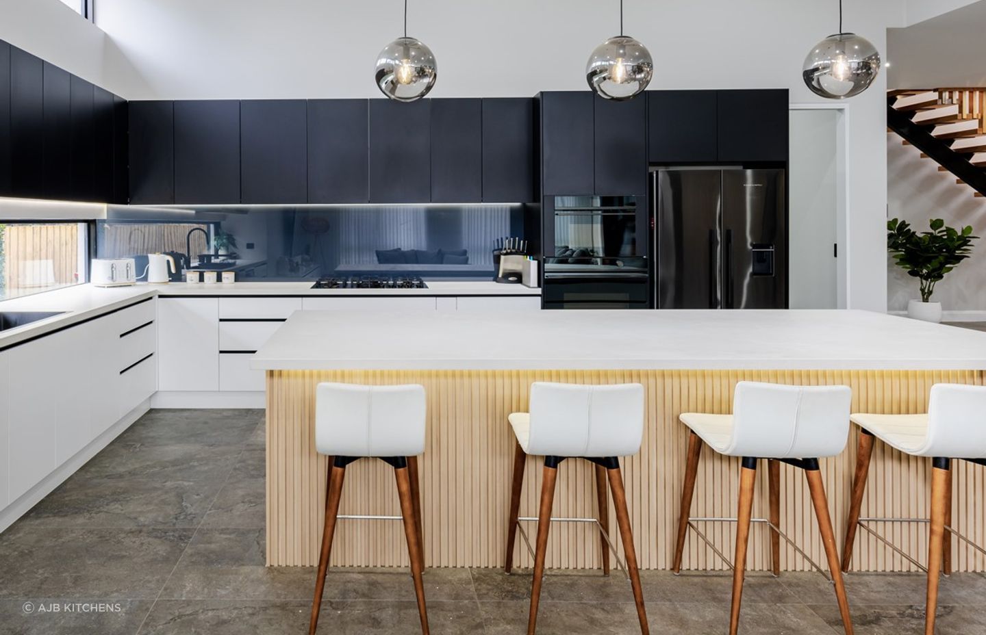 A stylish smoky mirror splashback in this luxury kitchen in Pennant Hills