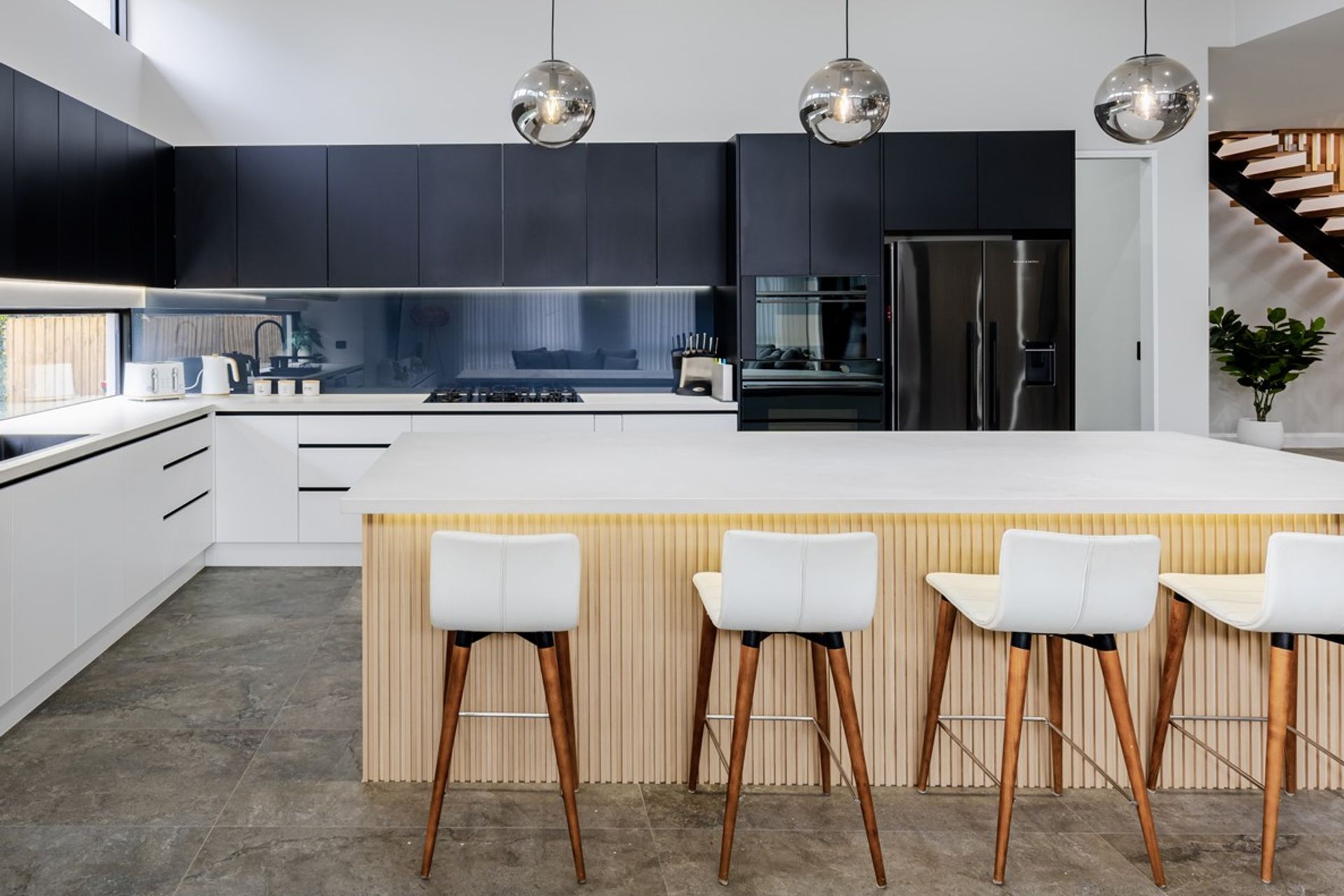 A stylish smoky mirror splashback in this luxury kitchen in Pennant Hills