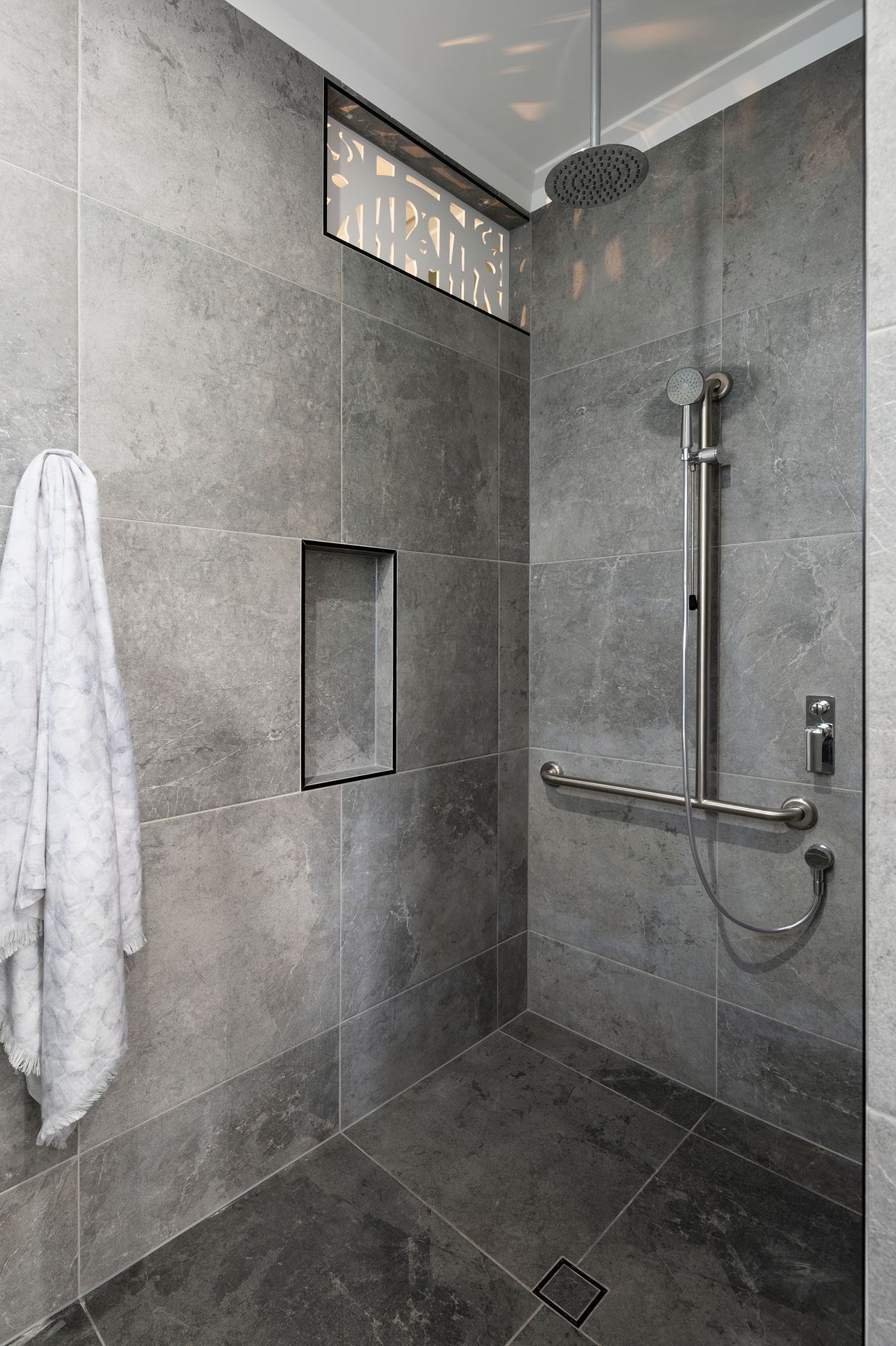 A grab bar and detatchable shower head make bathing more accessible | Auntie's Hut by 4305 Design | Photography by Angus Martin