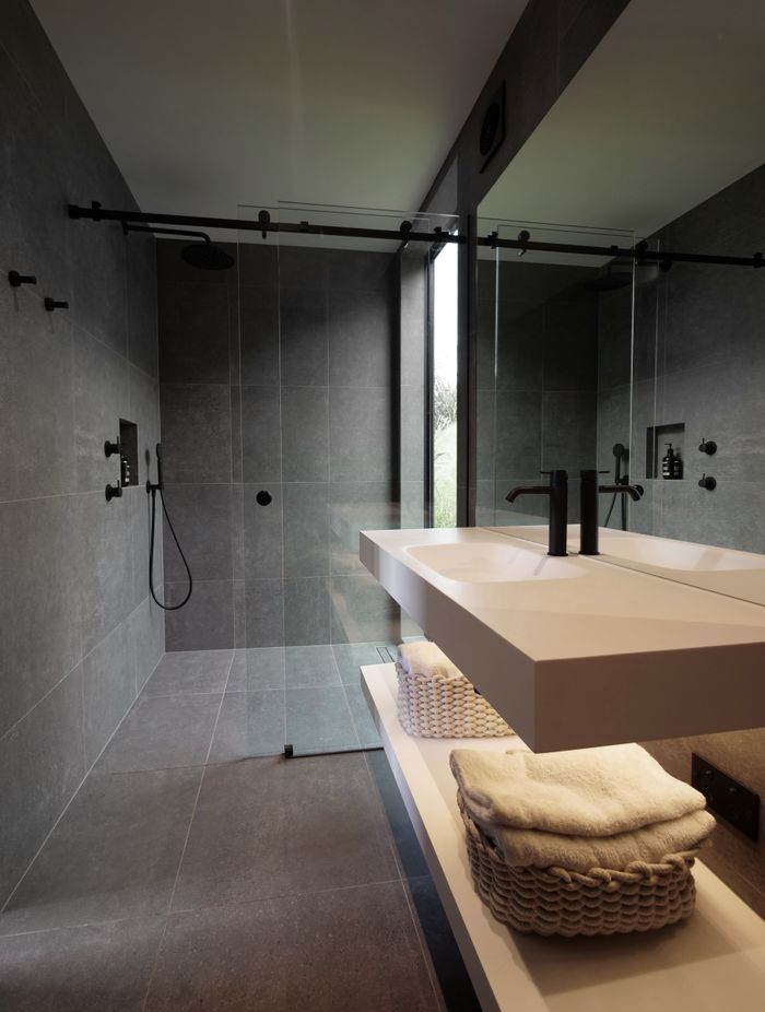 The serene tones of the bathroom compliment the overall material palette.